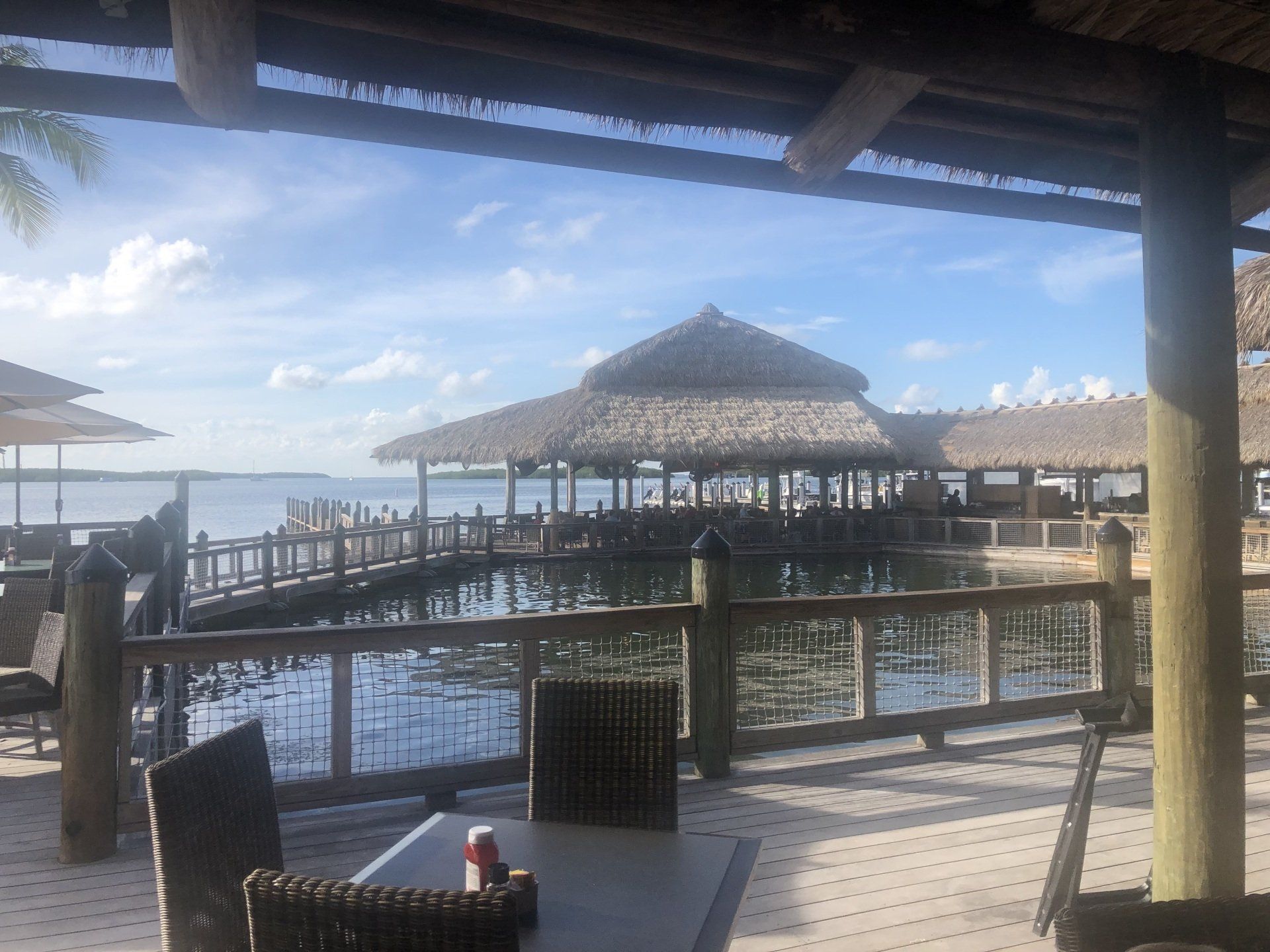 A patio with tables and chairs overlooking a body of water