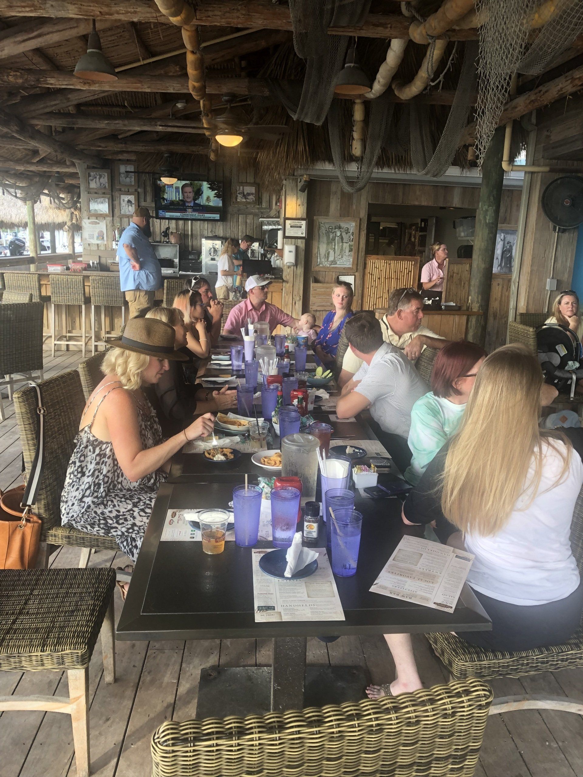 A group of people are sitting at long tables in a restaurant.