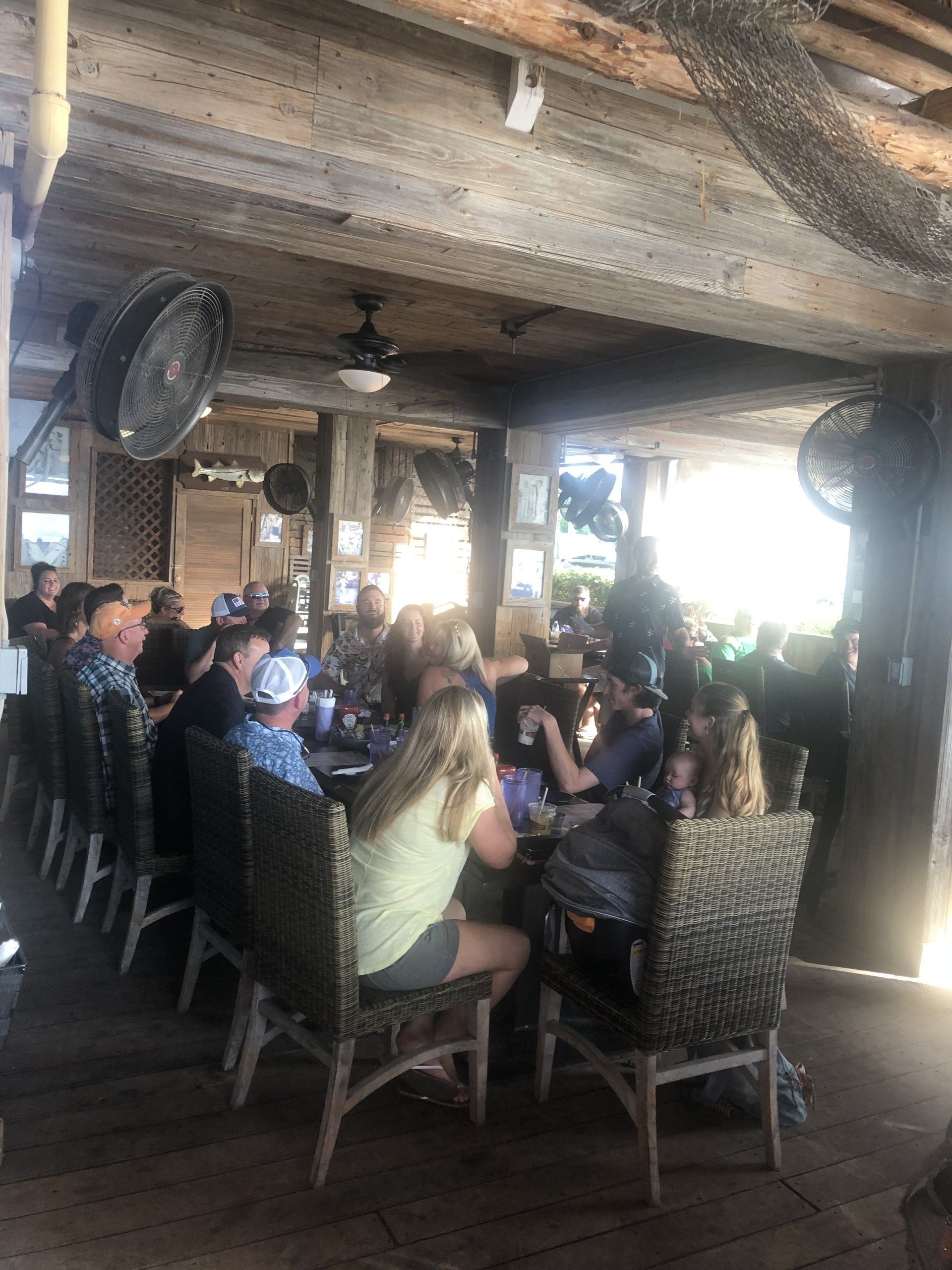 A group of people are sitting at tables in a restaurant.