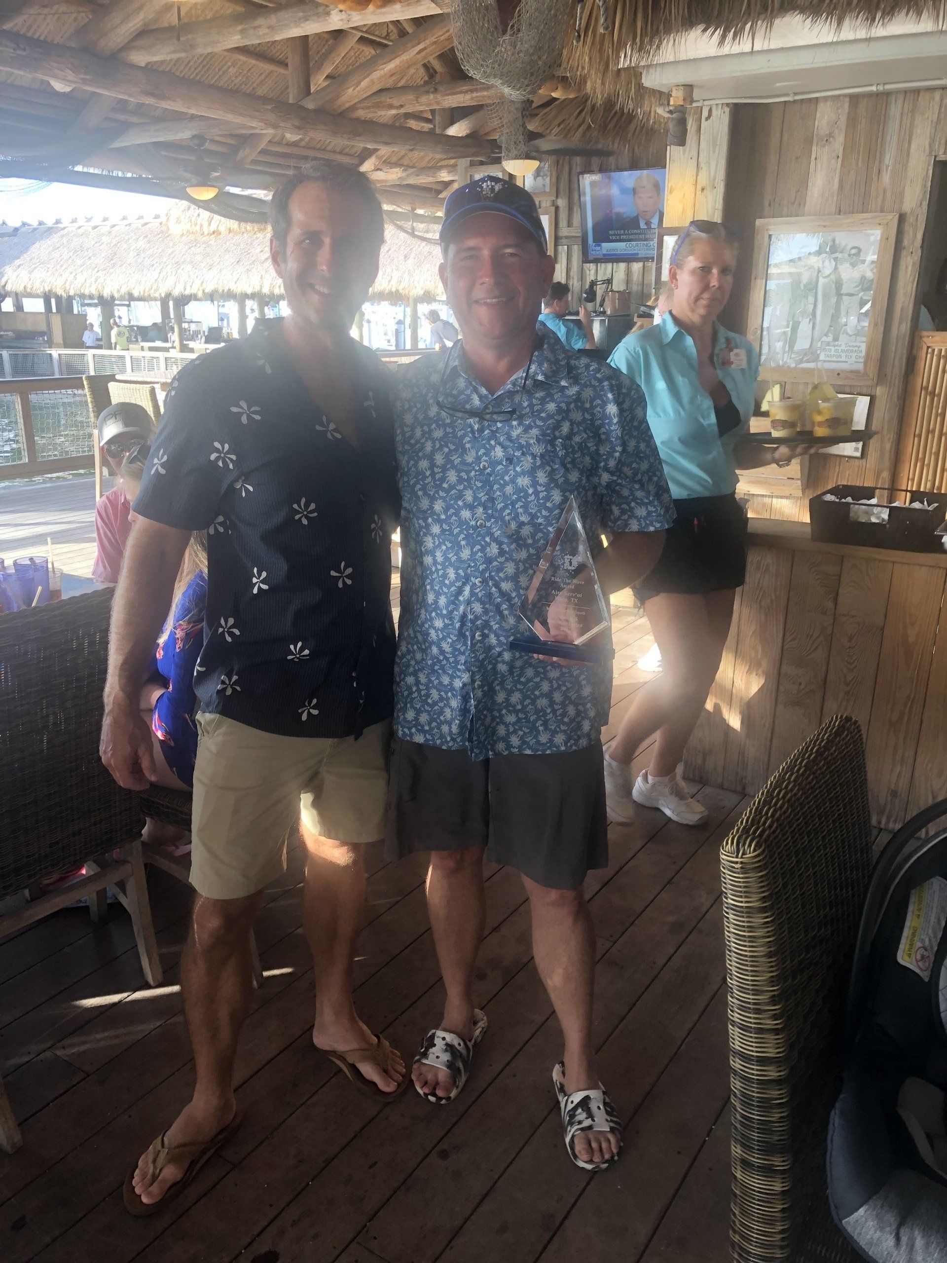 Two men are posing for a picture in a restaurant.