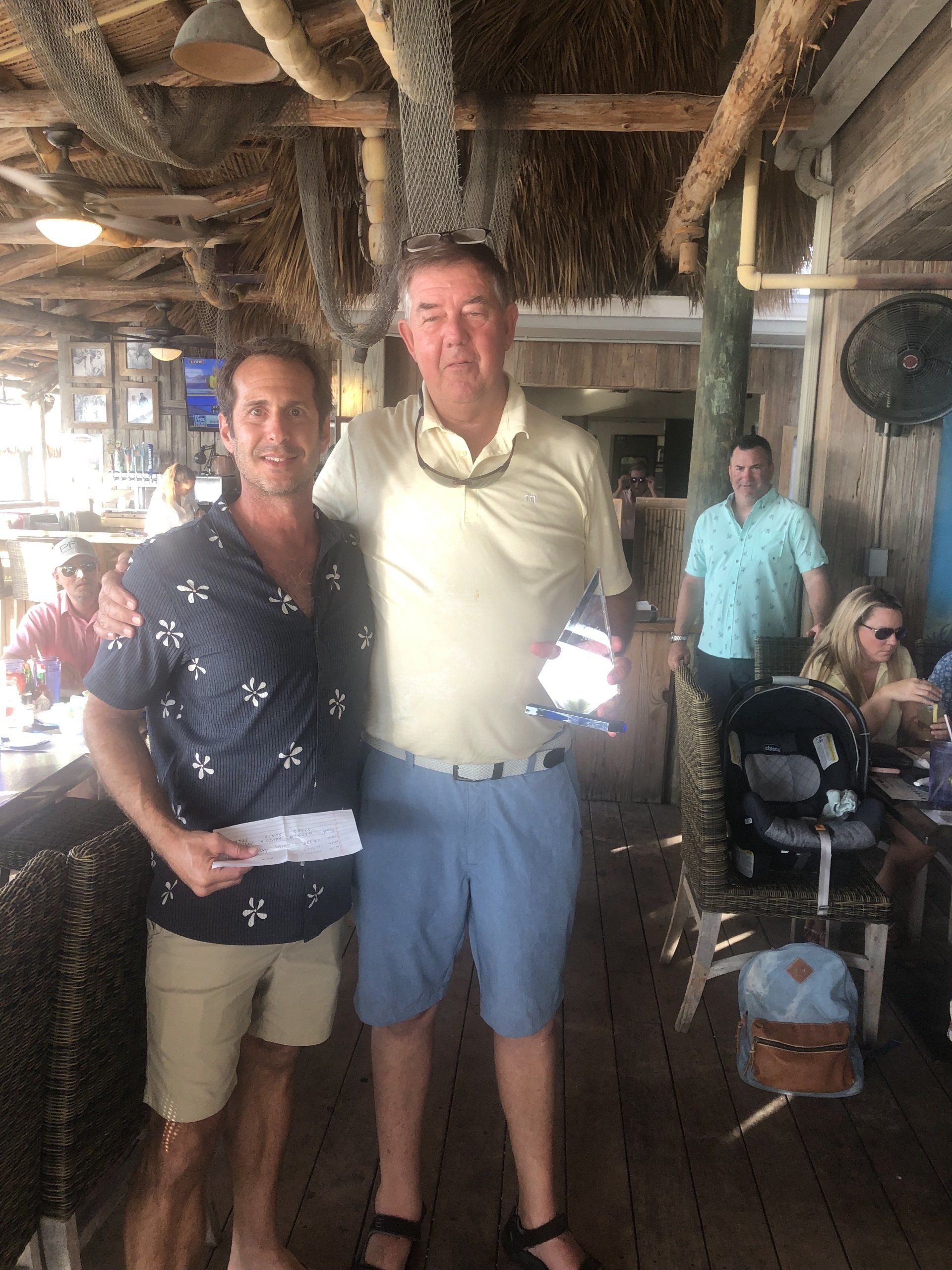 Two men are posing for a picture in a restaurant.