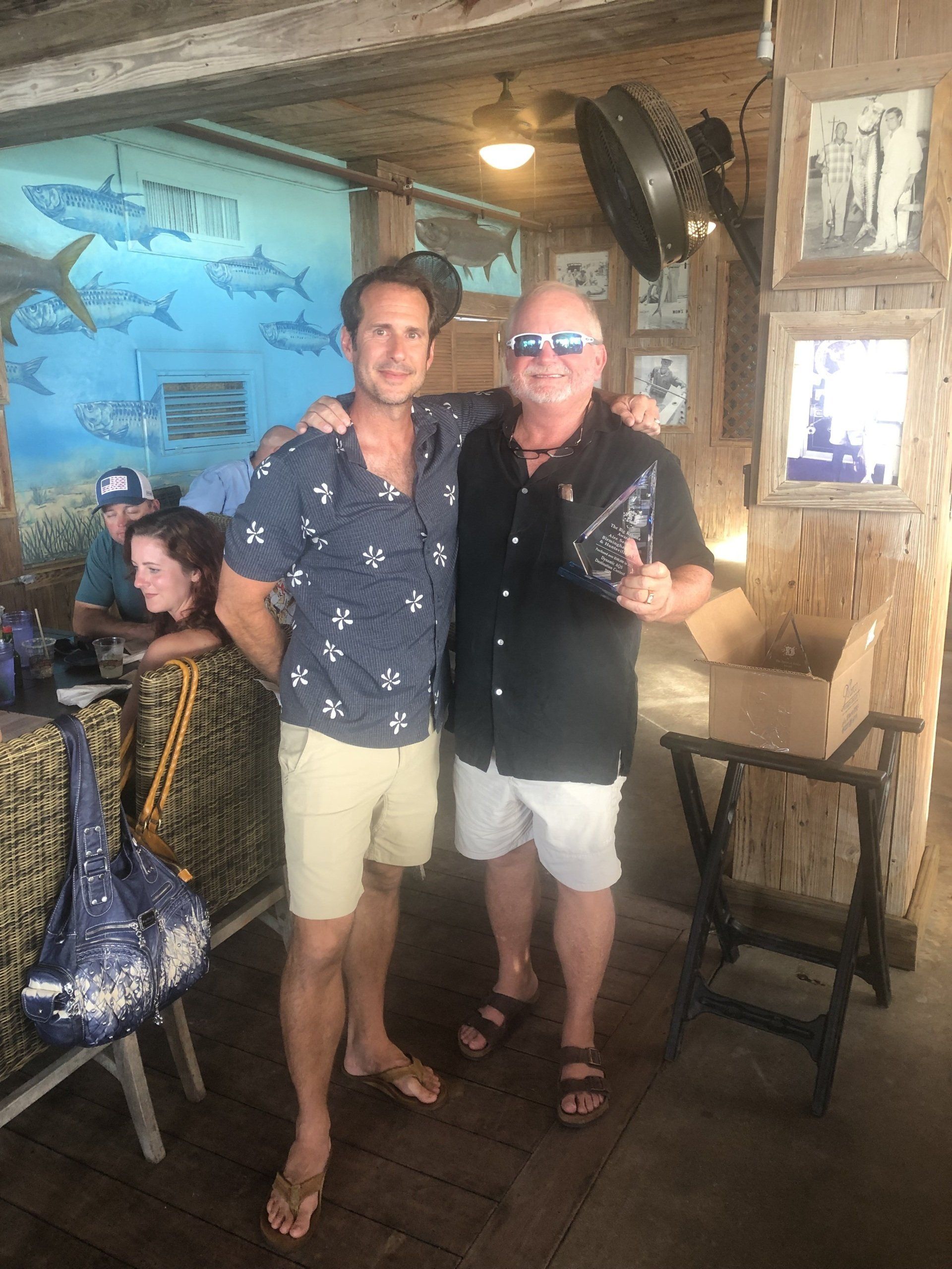 Two men are posing for a picture in a restaurant.