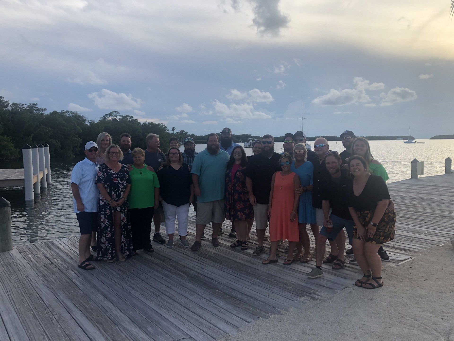 A group of people are posing for a picture on a dock.
