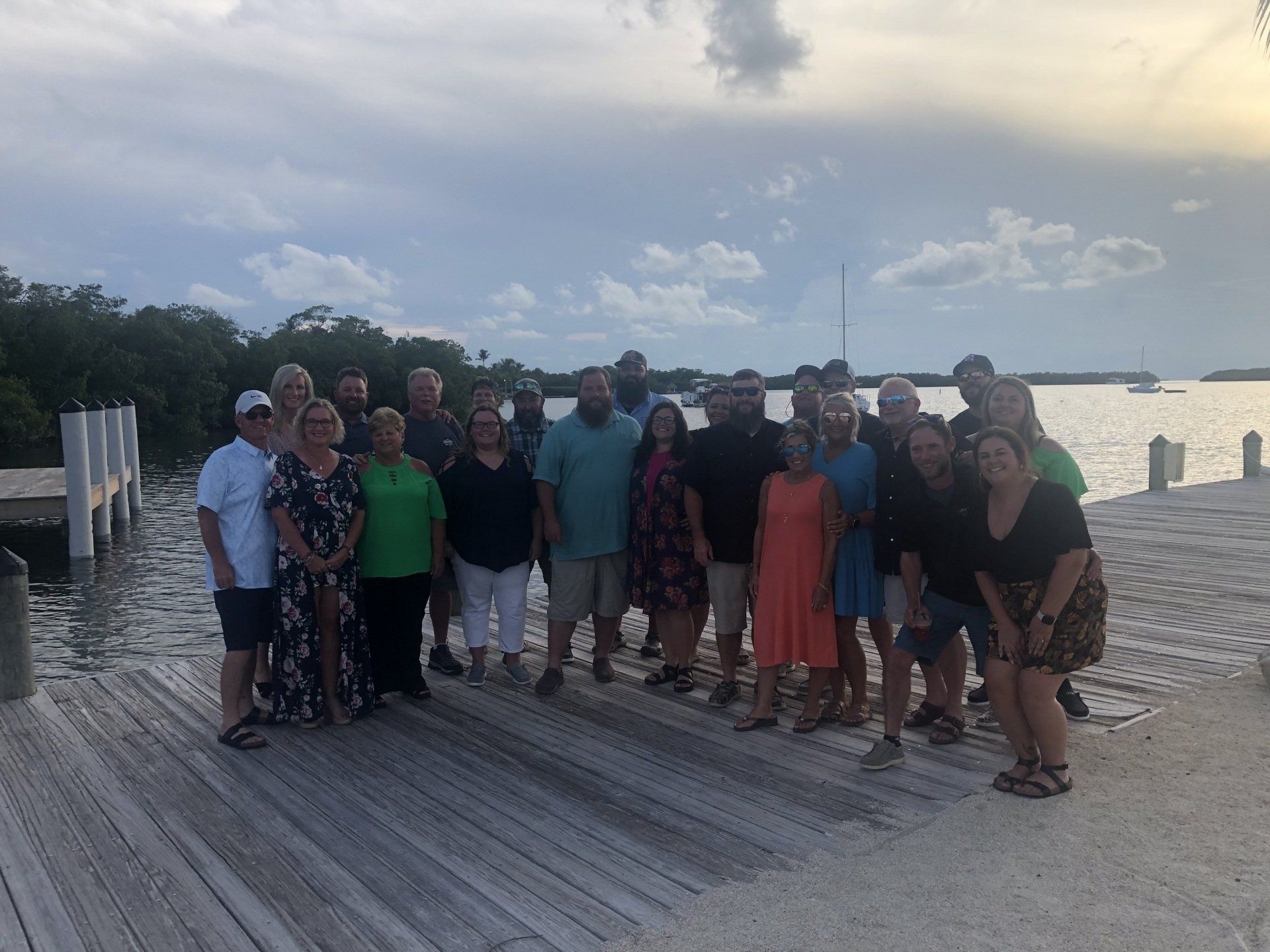 A group of people are posing for a picture on a dock.