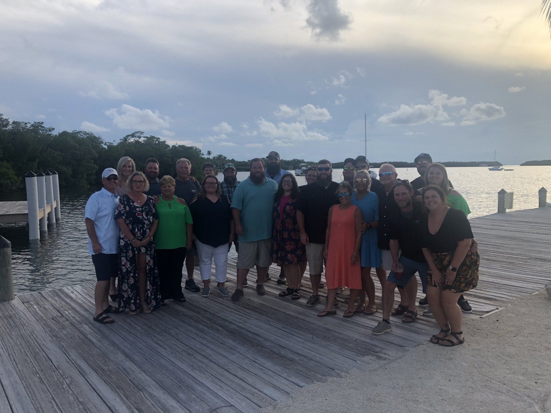 A group of people are posing for a picture on a dock.