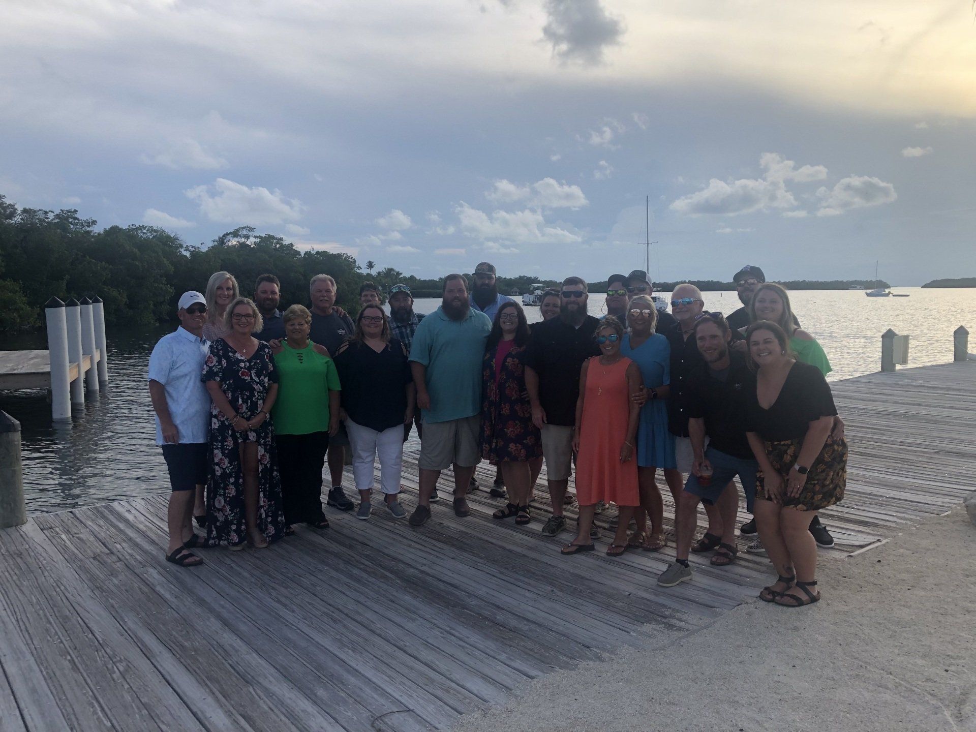 A group of people are posing for a picture on a dock.