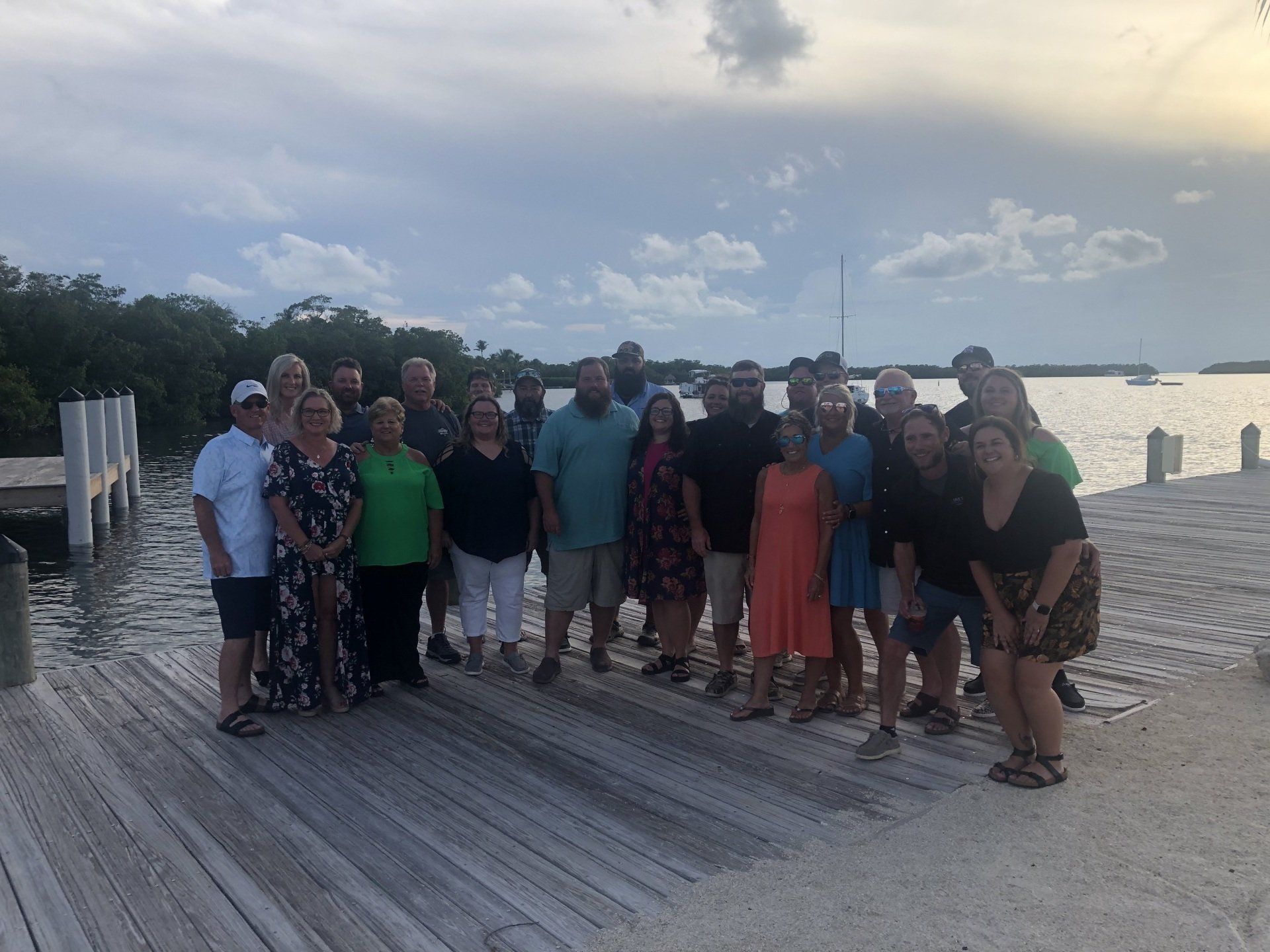 A group of people are posing for a picture on a dock.