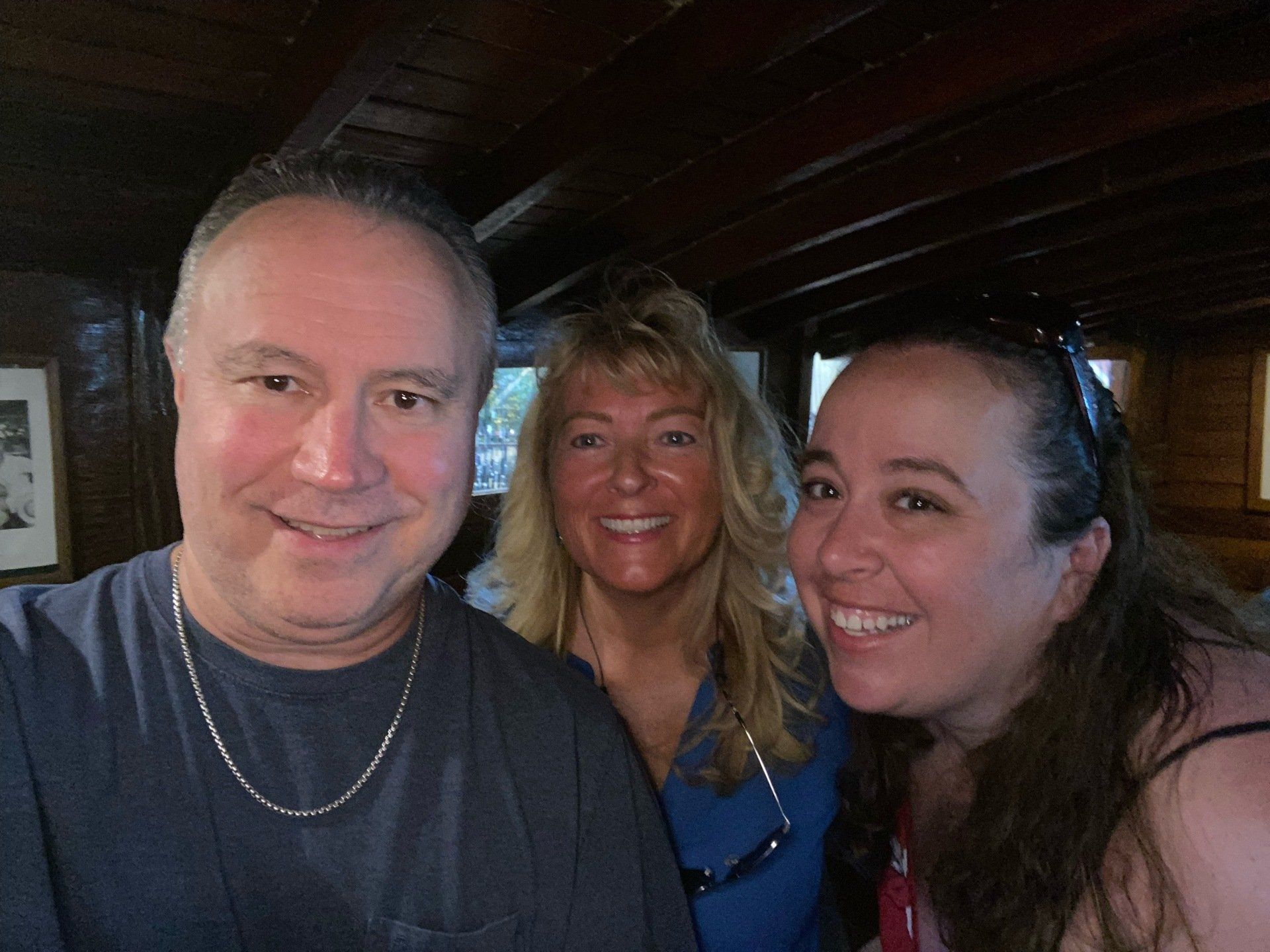 A man and two women are posing for a picture together.