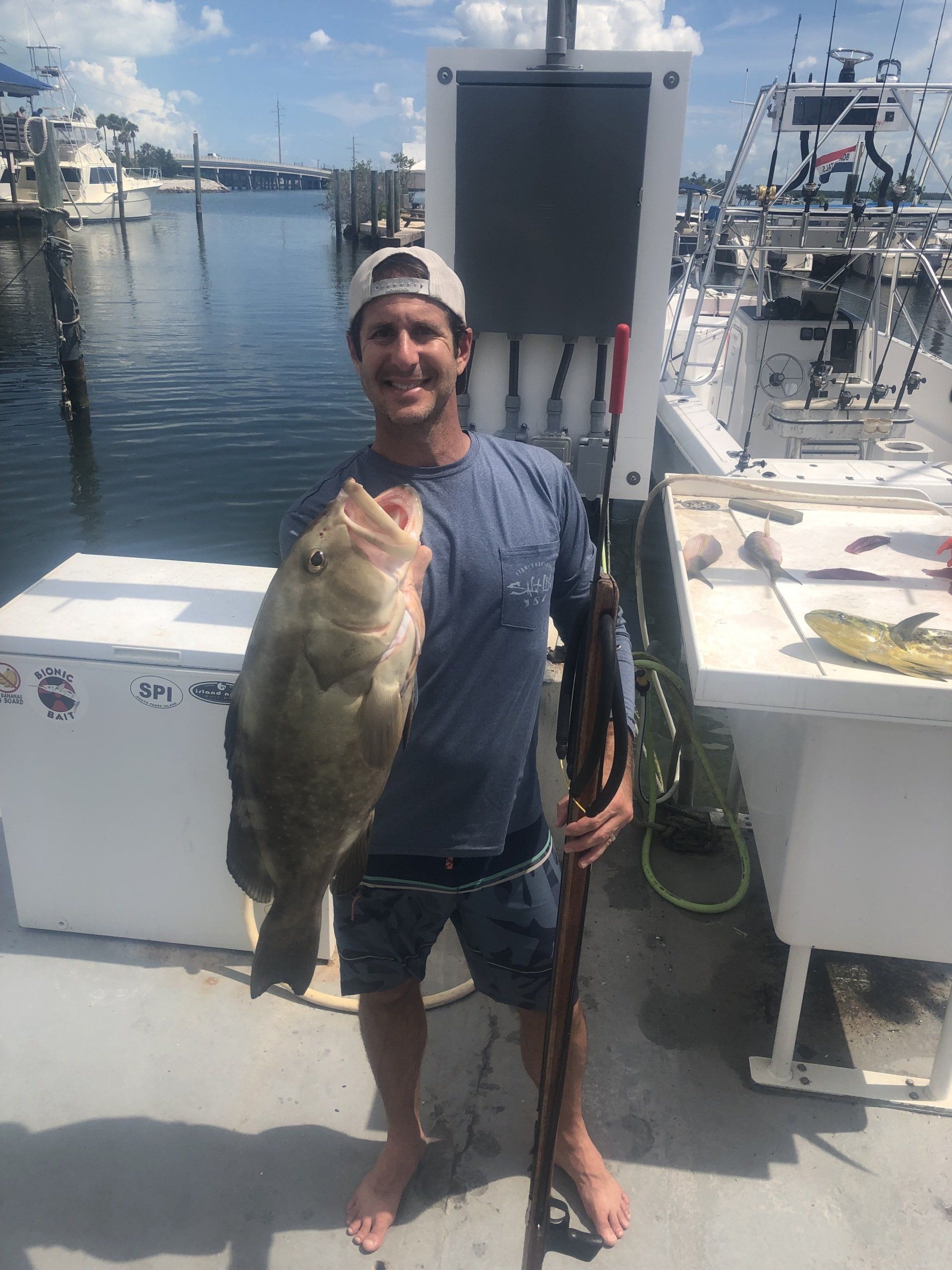 A man is holding a large fish on a boat.