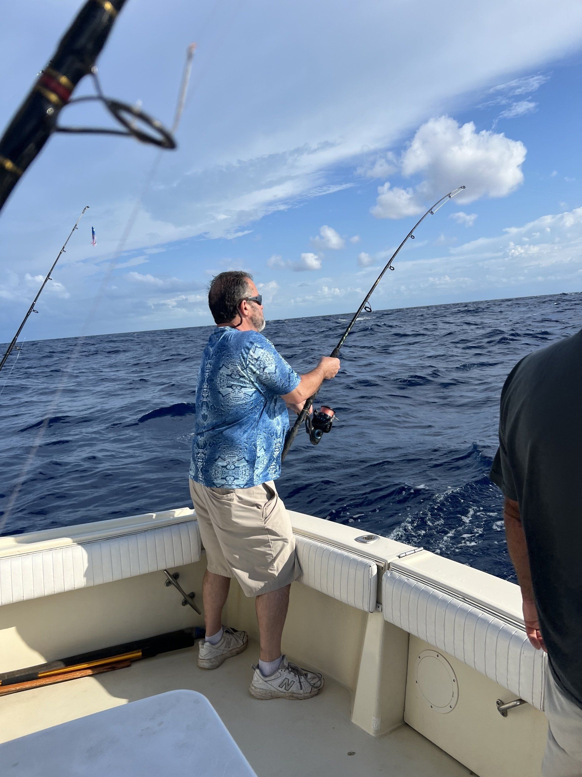 A man is fishing on a boat in the ocean