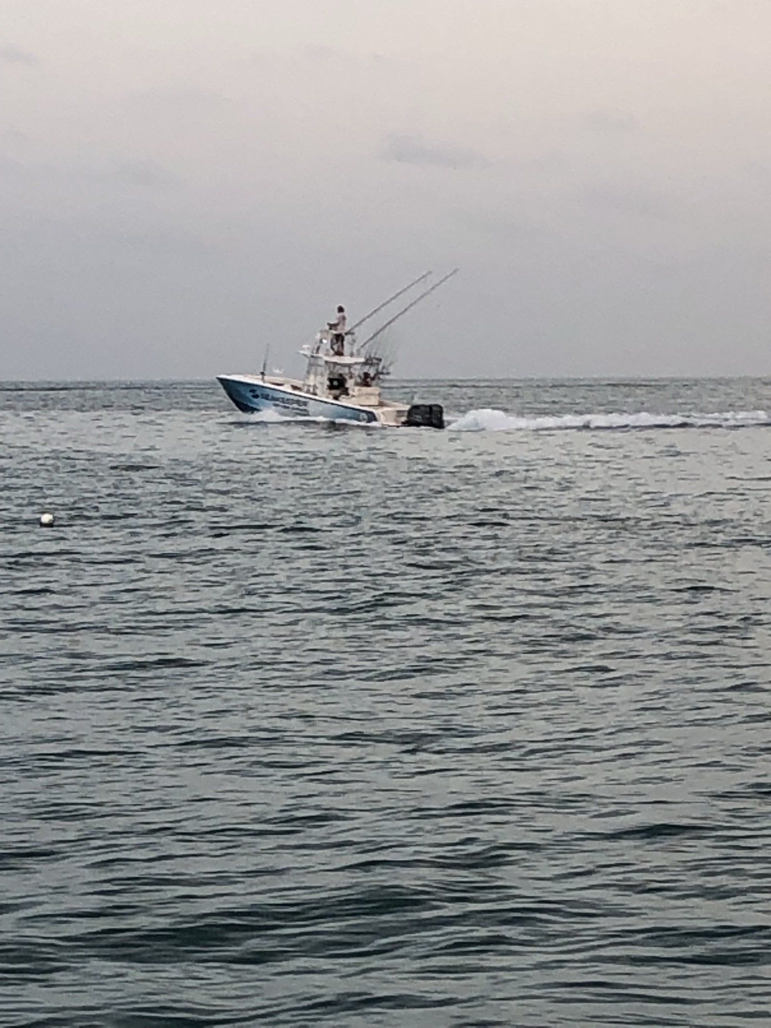 A boat is floating on top of a large body of water.