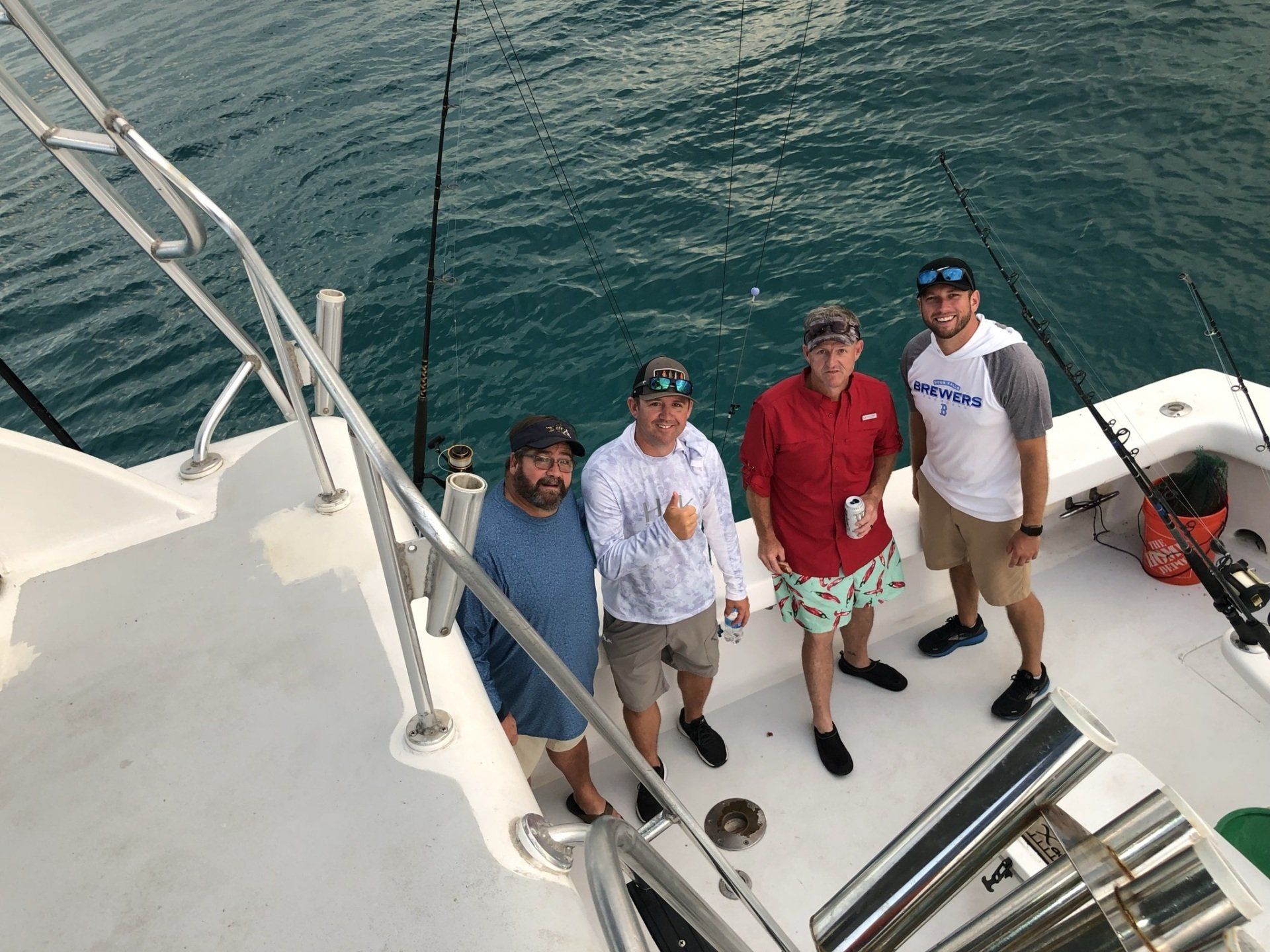 A group of men are standing on the deck of a boat in the water.