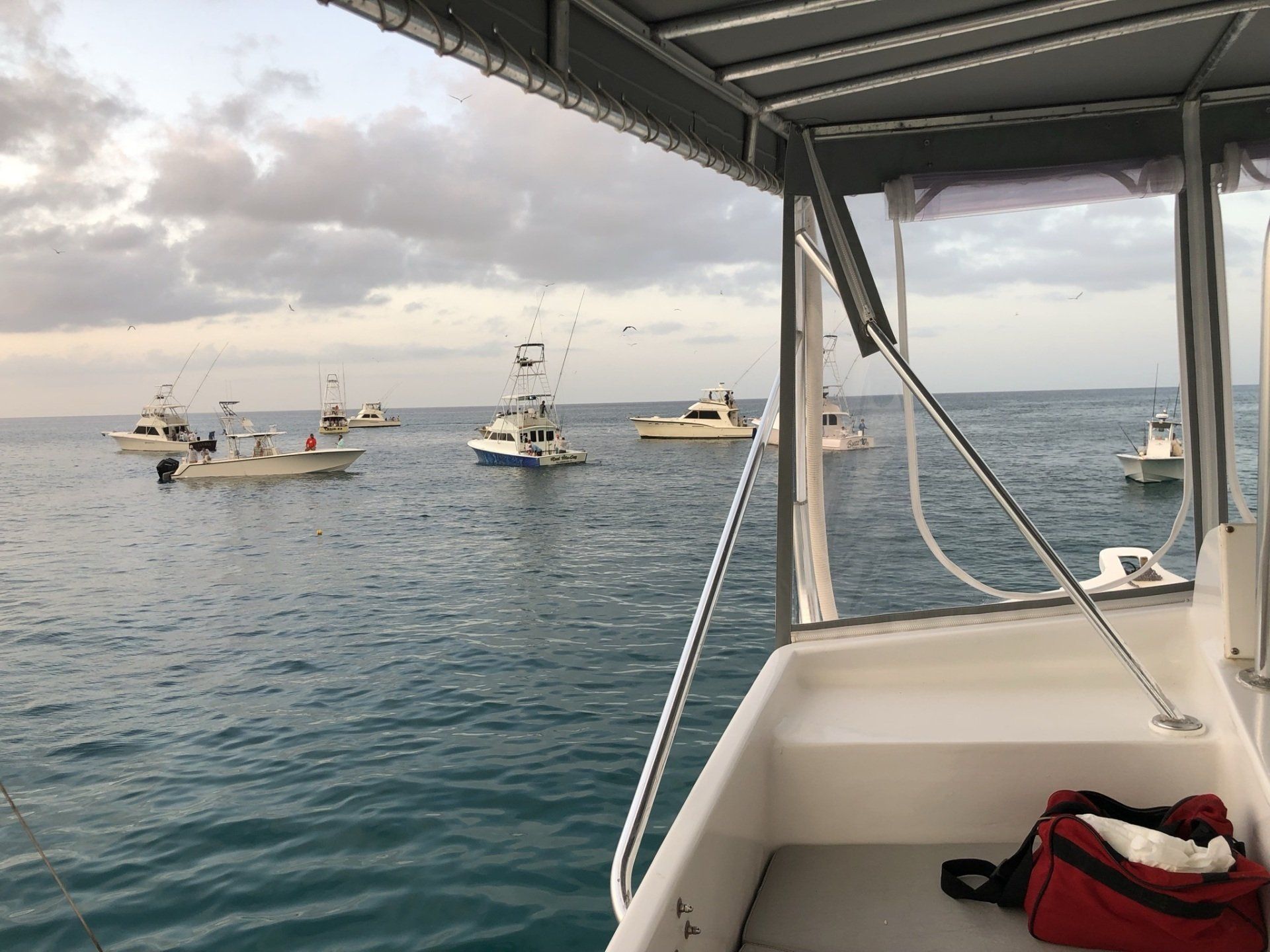 A boat is floating in the ocean with boats in the background