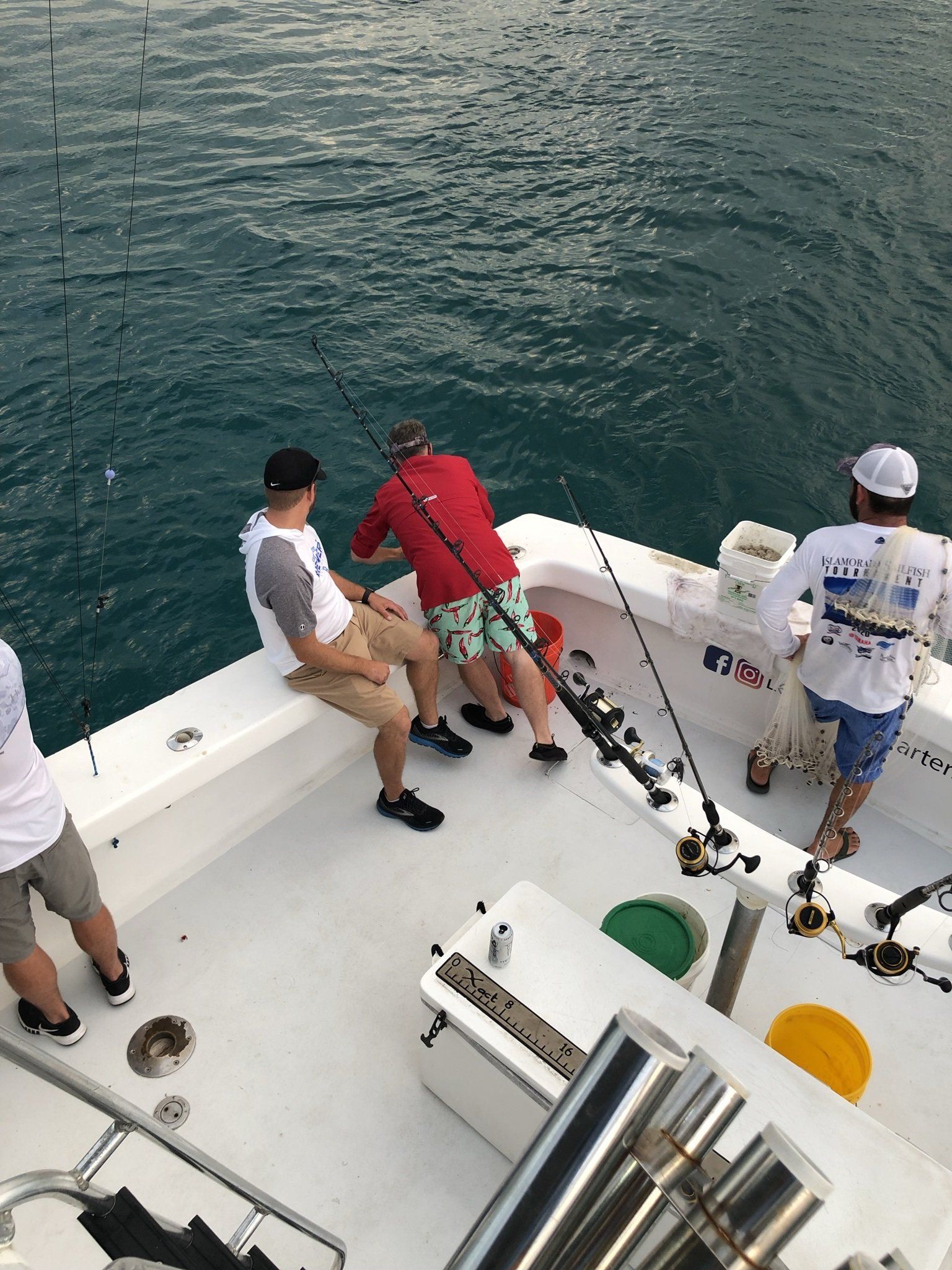 A group of men are fishing on a boat in the ocean.