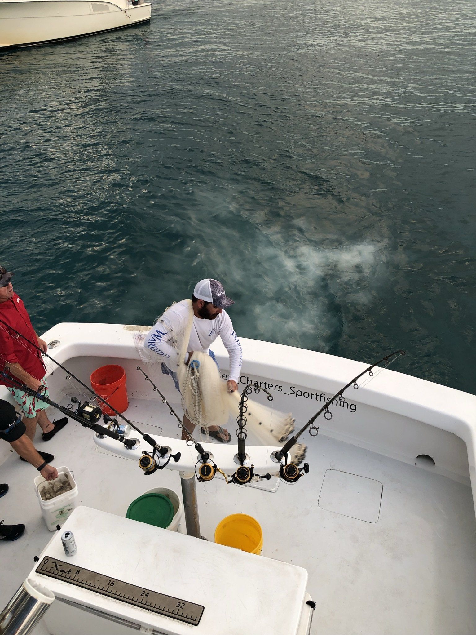 A man is fishing on a boat in the ocean.