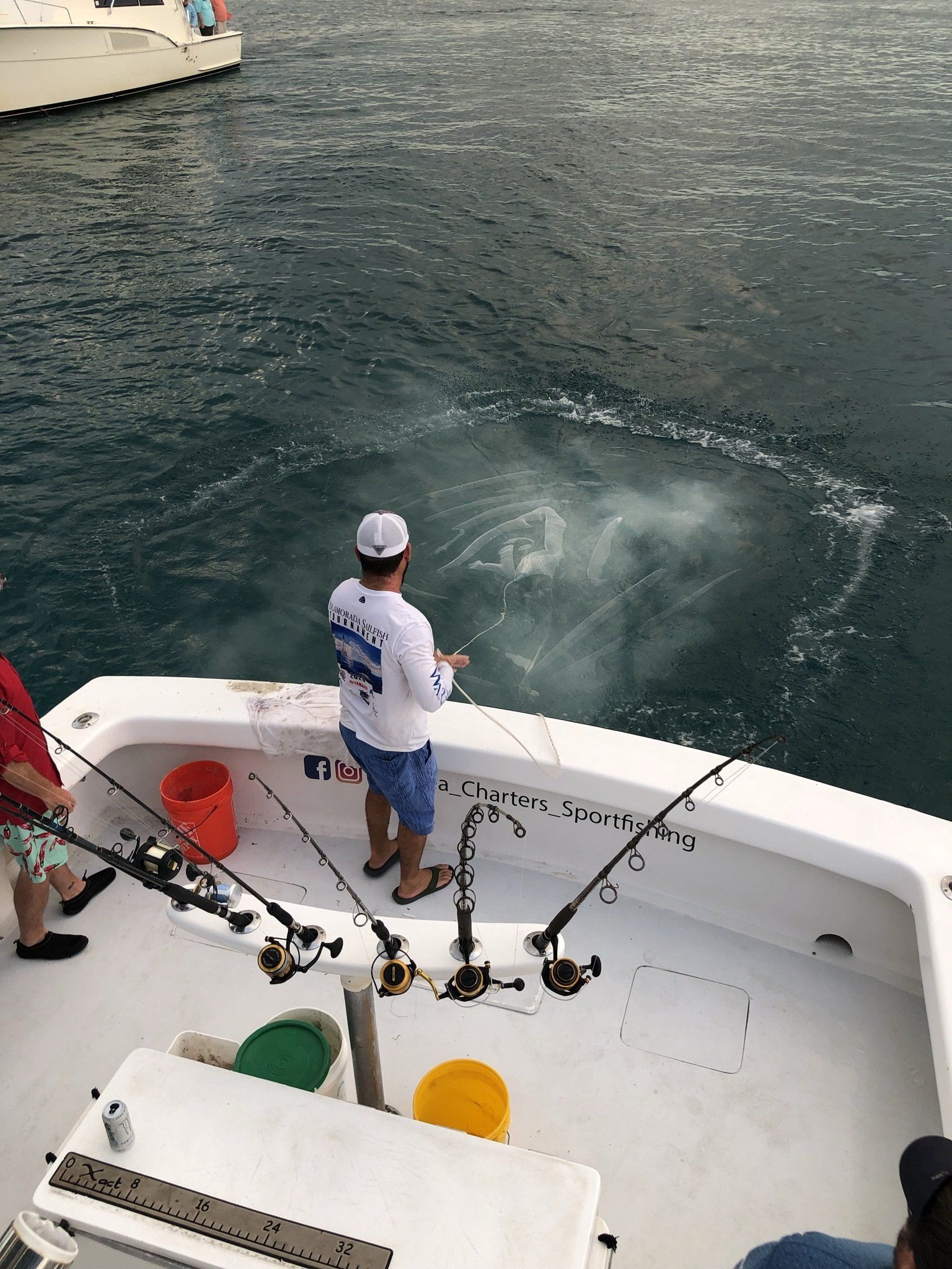 A man is fishing on a boat in the ocean.