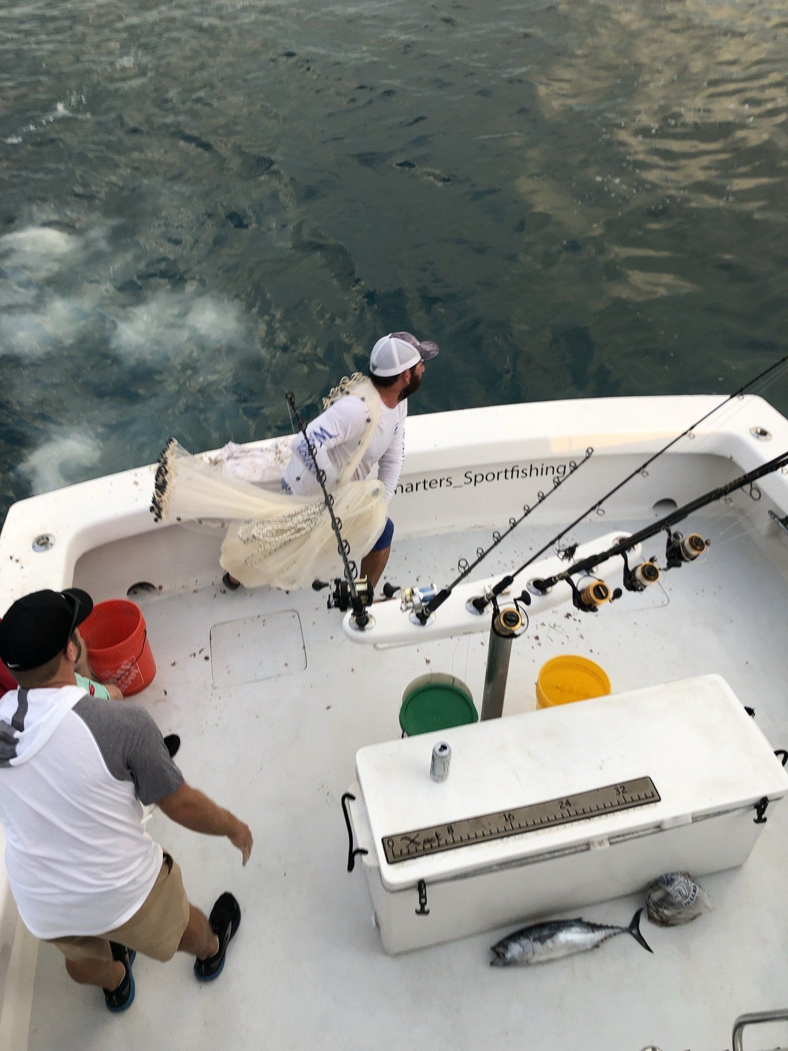 Two men are fishing on a boat in the ocean