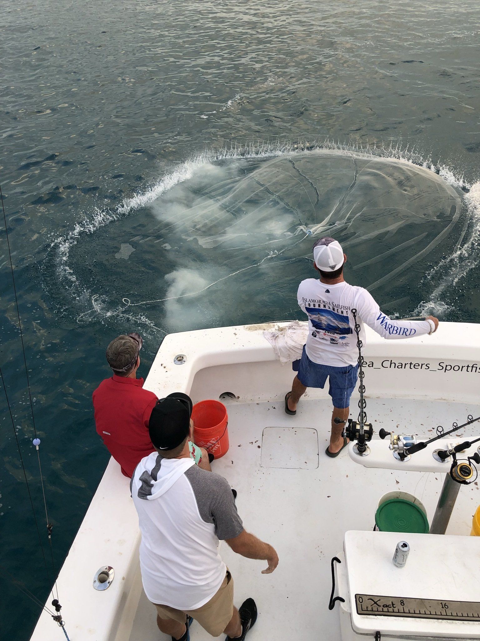 A group of men are fishing on a boat in the ocean.