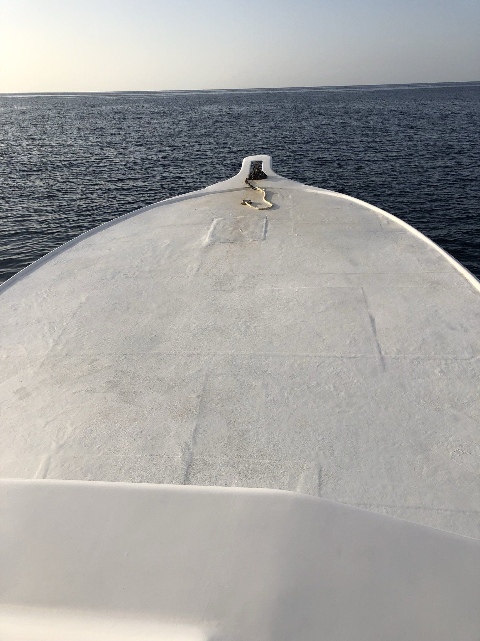 A white boat is floating on top of a large body of water.