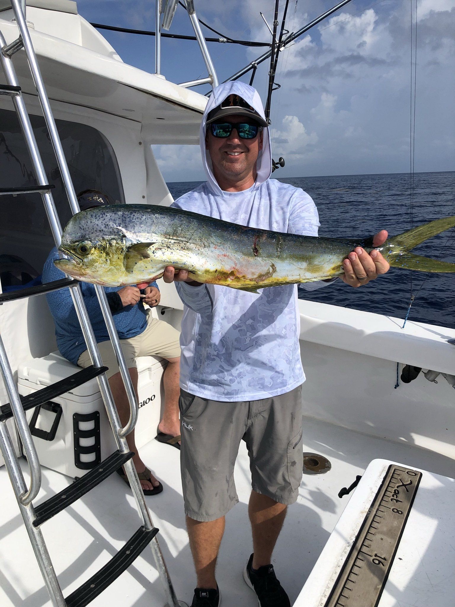 A man is holding a large fish on a boat.