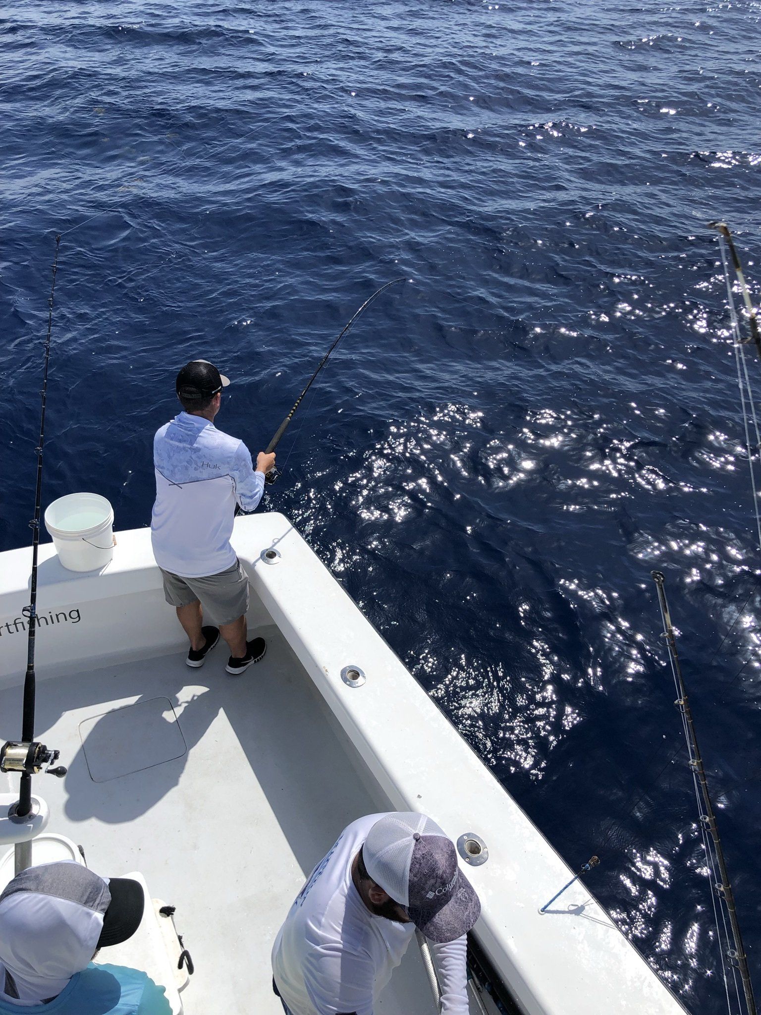 A man is fishing on a boat in the ocean.