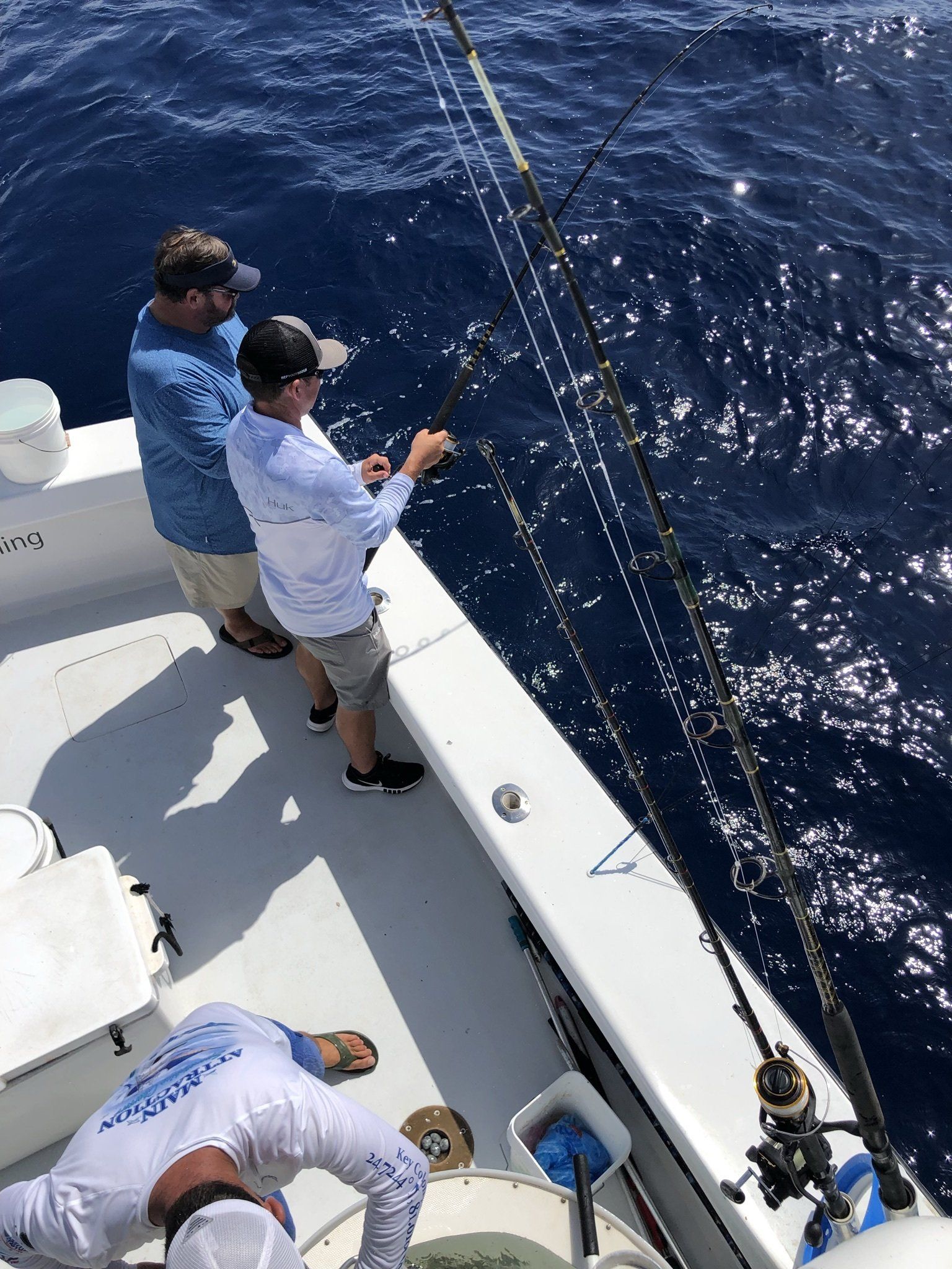 A group of men are fishing on a boat in the ocean.