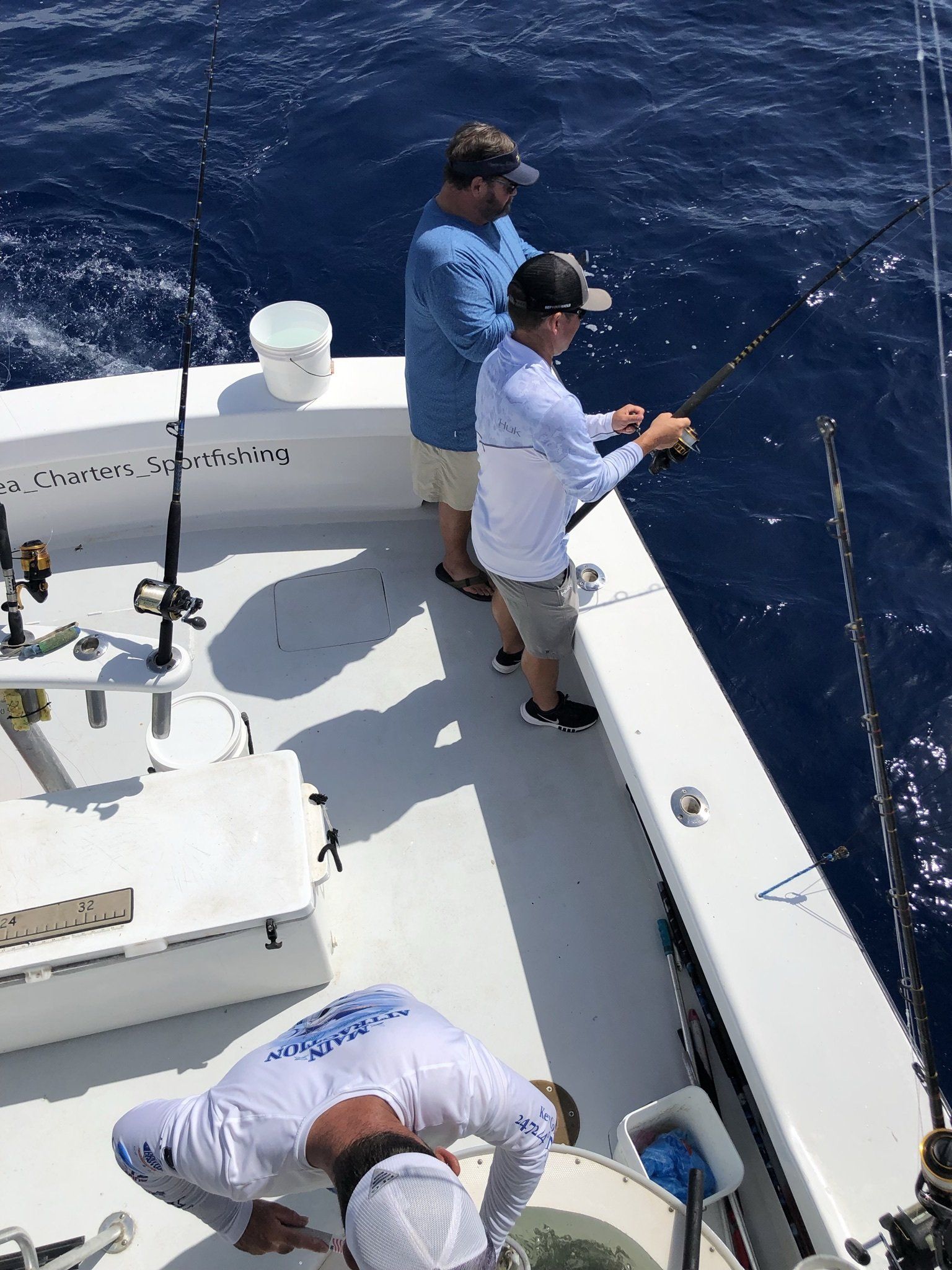 A group of men are fishing on a boat in the ocean.