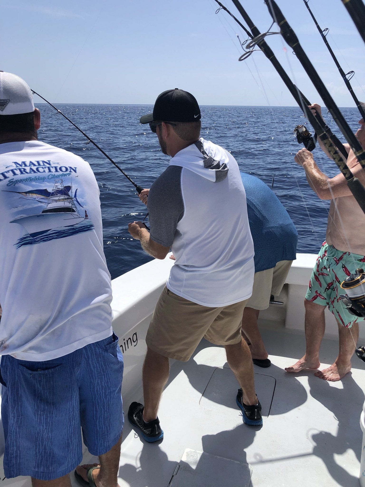 A group of men are fishing on a boat in the ocean.