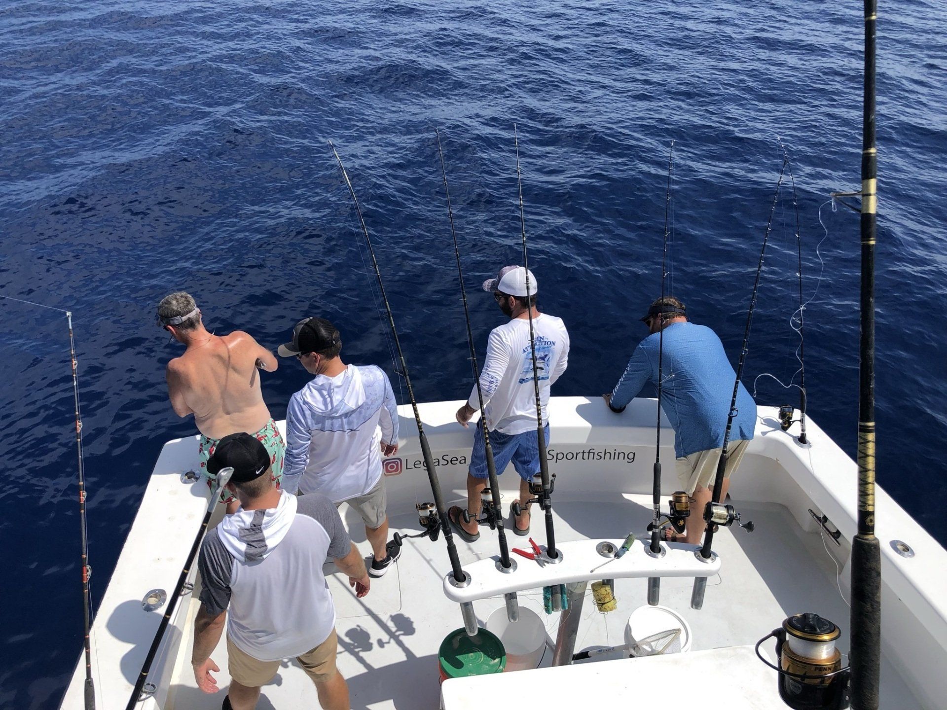 A group of men are fishing on a boat in the ocean.
