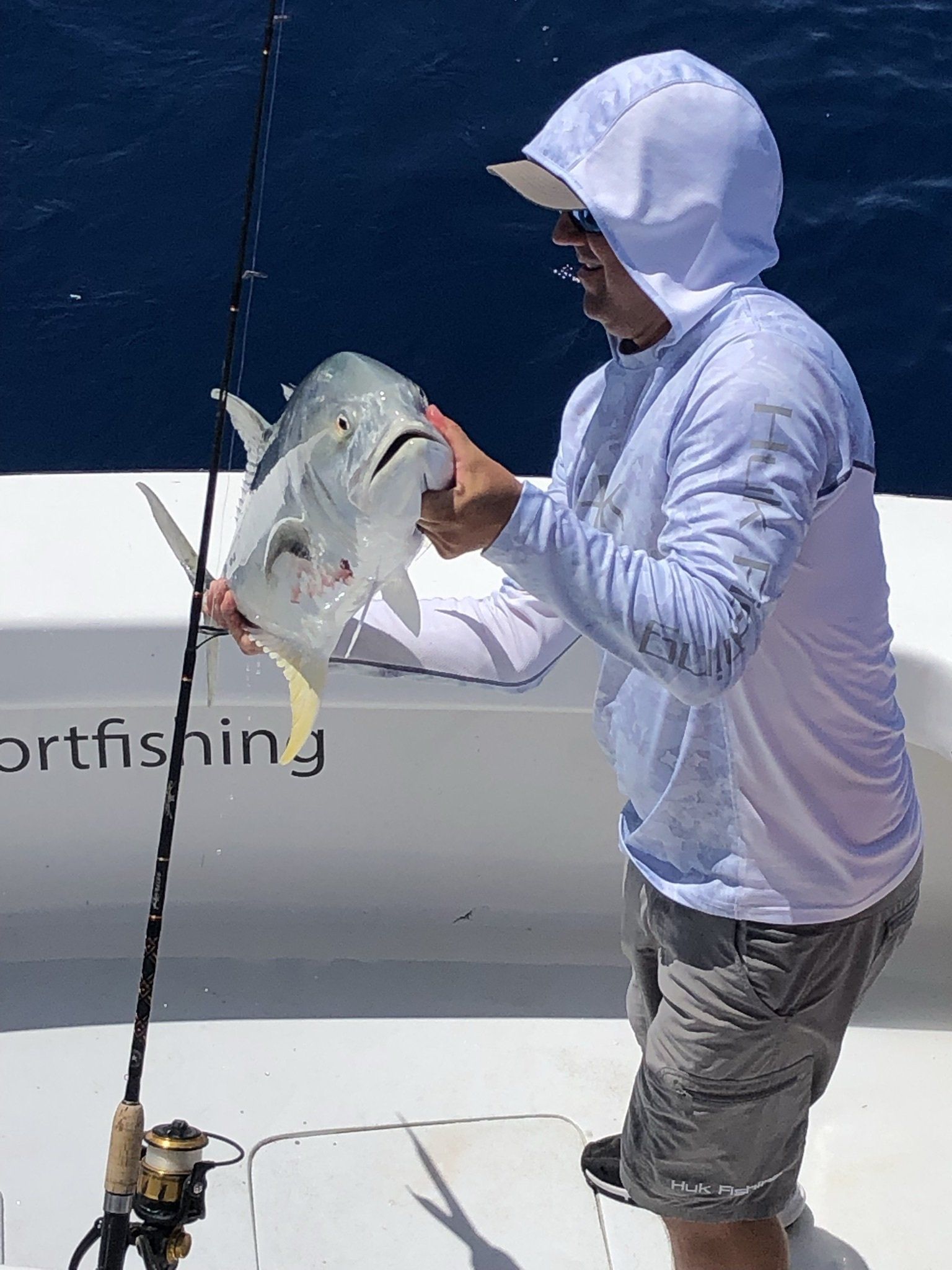 A man is holding a fish on a boat.