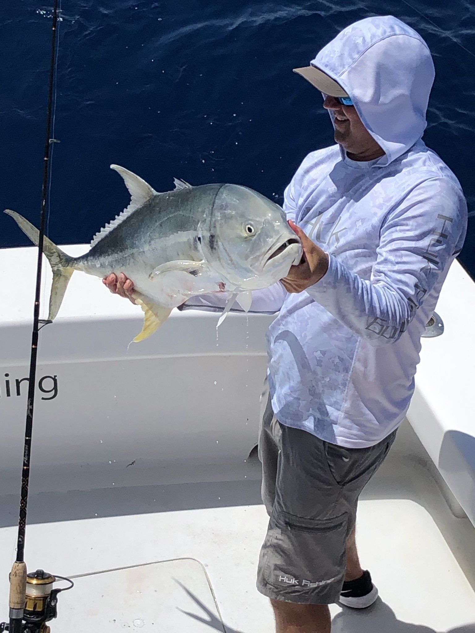 A man is holding a large fish on a boat.