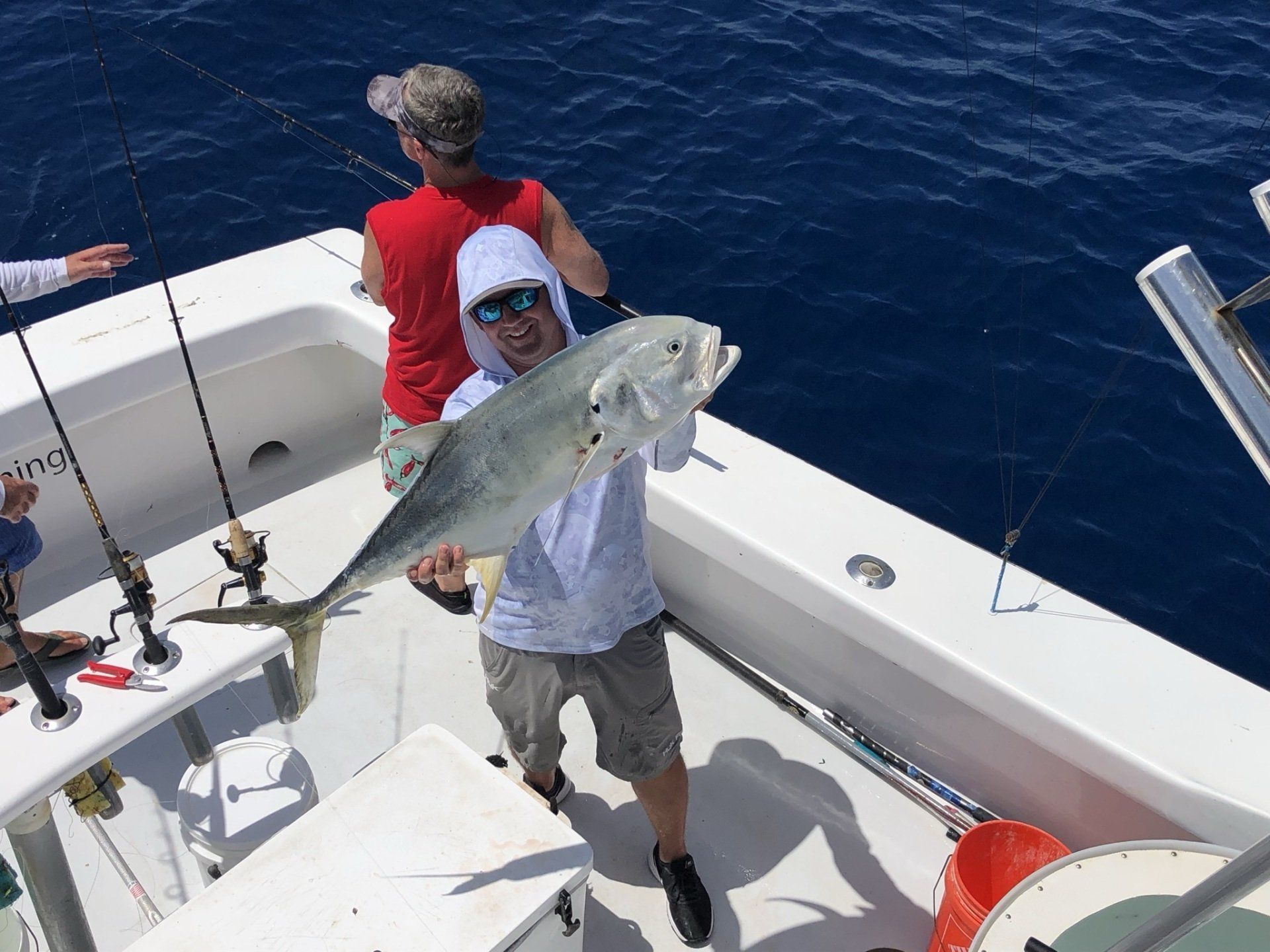 A man is holding a large fish on a boat.