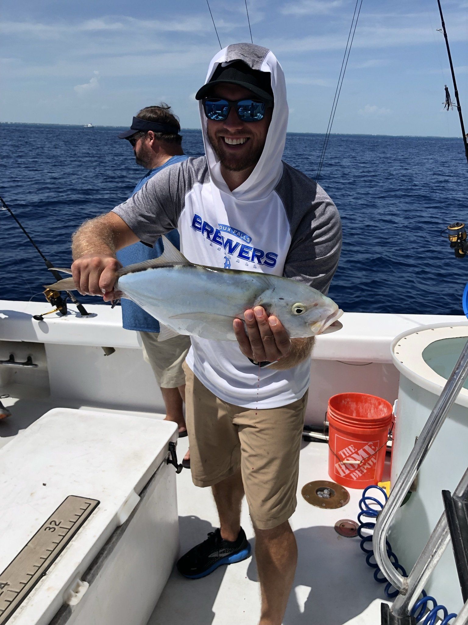 A man is holding a fish on a boat in the ocean.