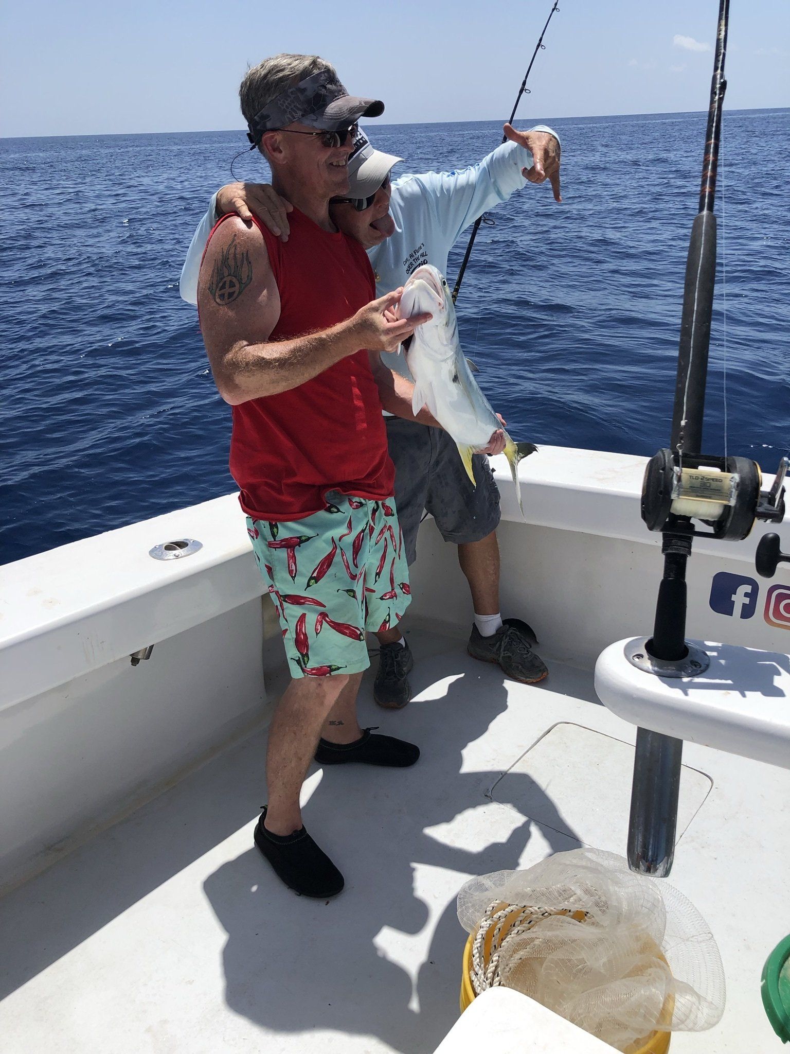 Two men are fishing on a boat in the ocean.