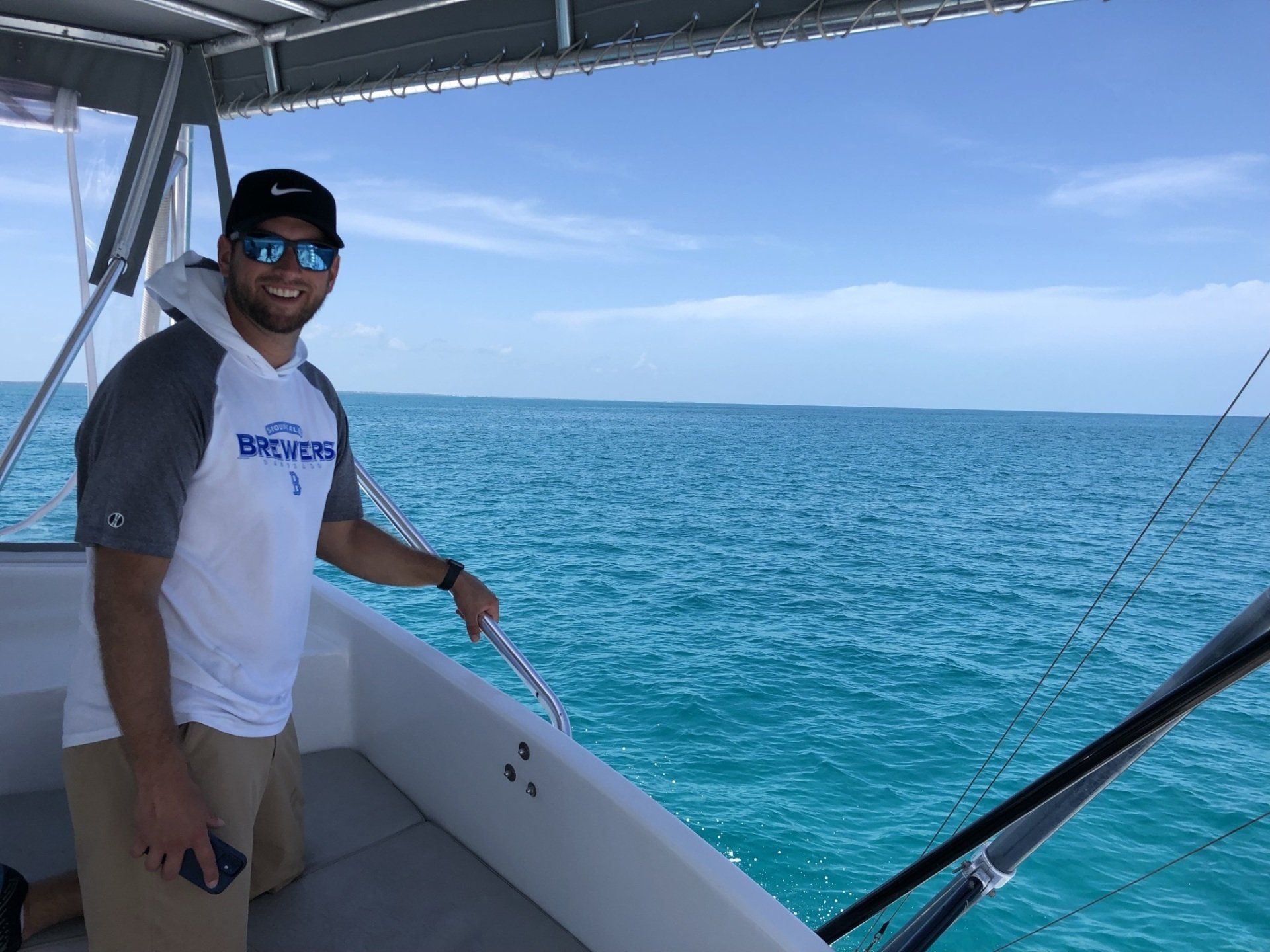 A man is standing on a boat in the ocean.