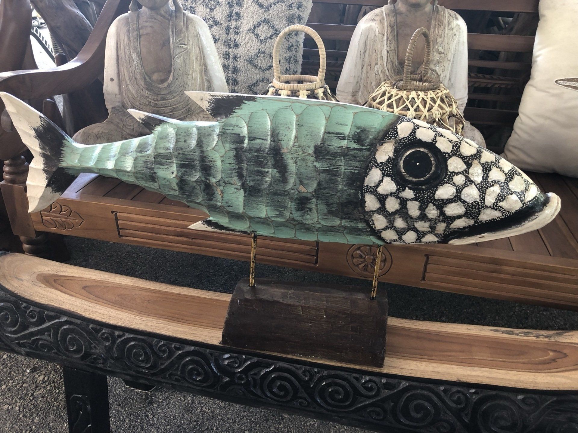 A statue of a fish is sitting on top of a wooden table.