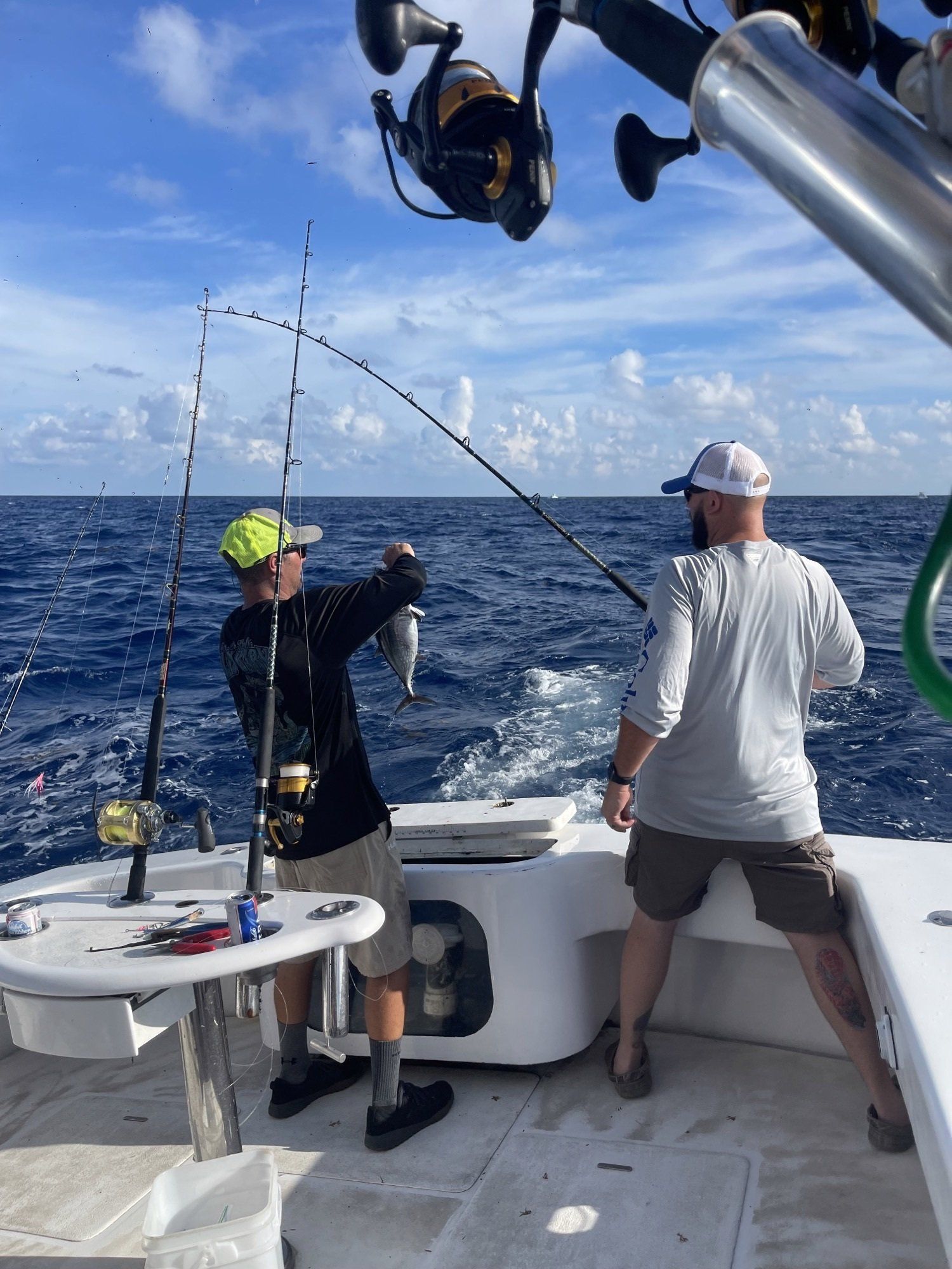 Two men are fishing in the ocean on a boat