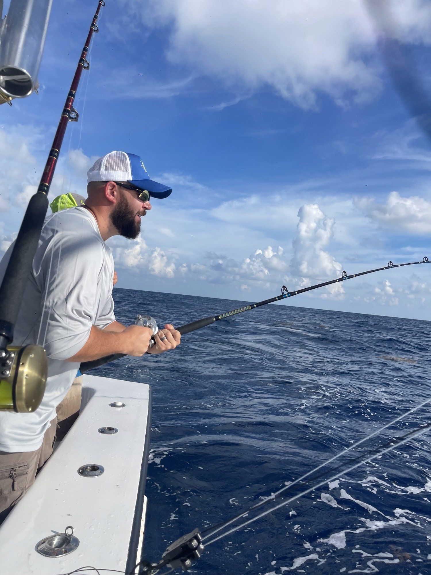 A man is fishing on a boat in the ocean.