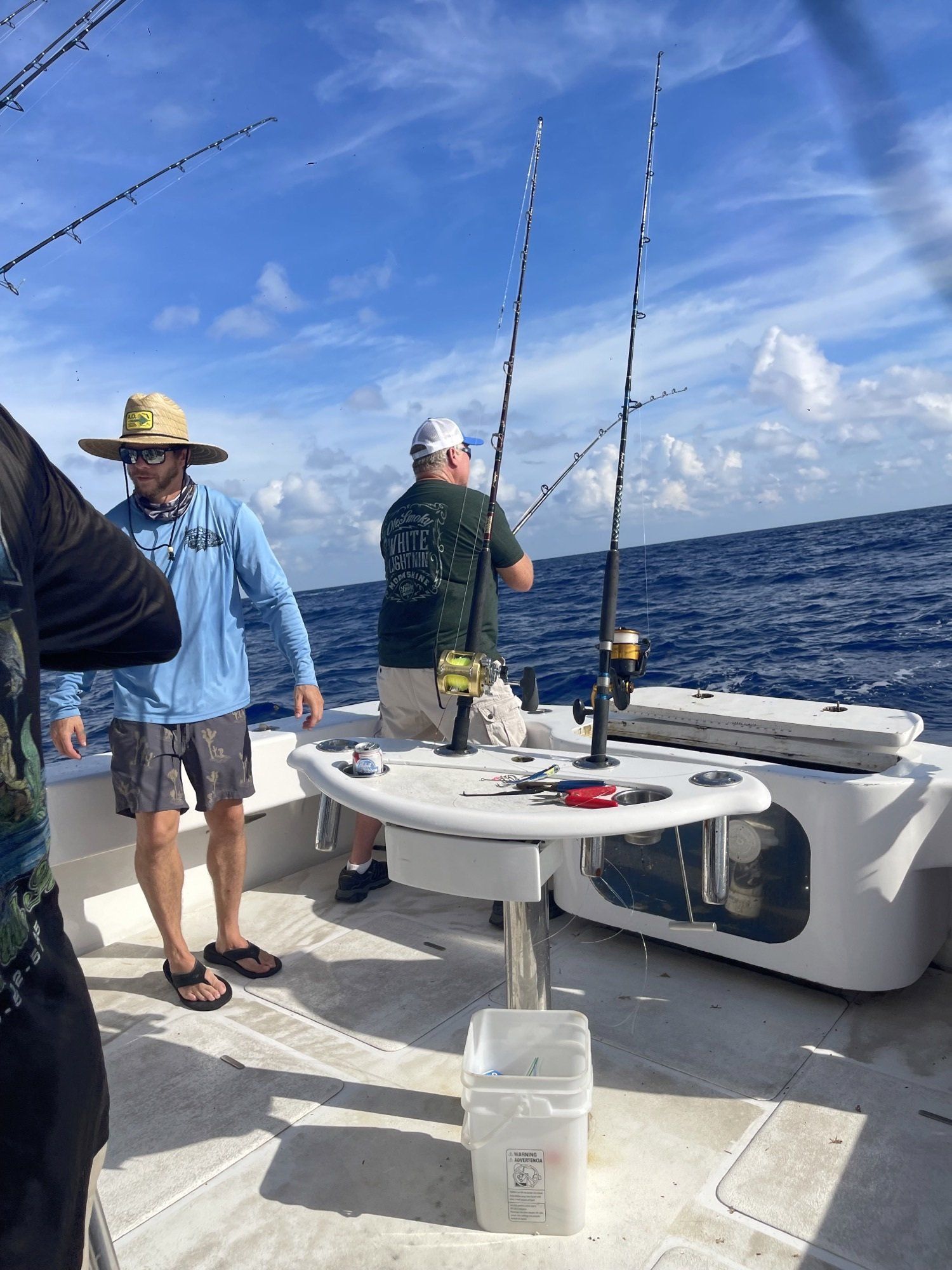 A group of men are fishing on a boat in the ocean.
