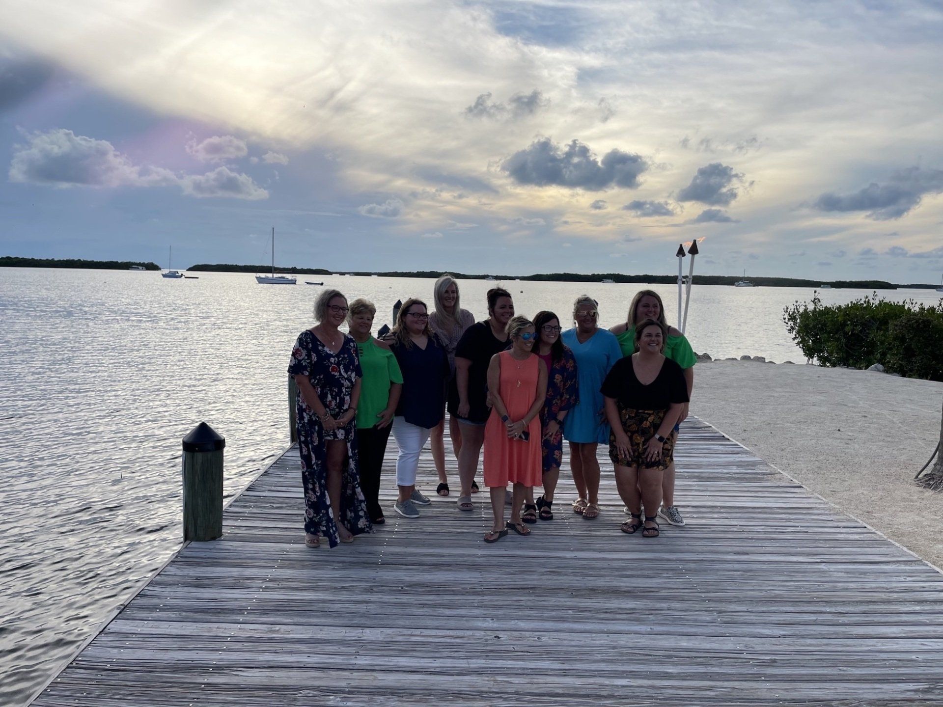 A group of people are posing for a picture on a dock.