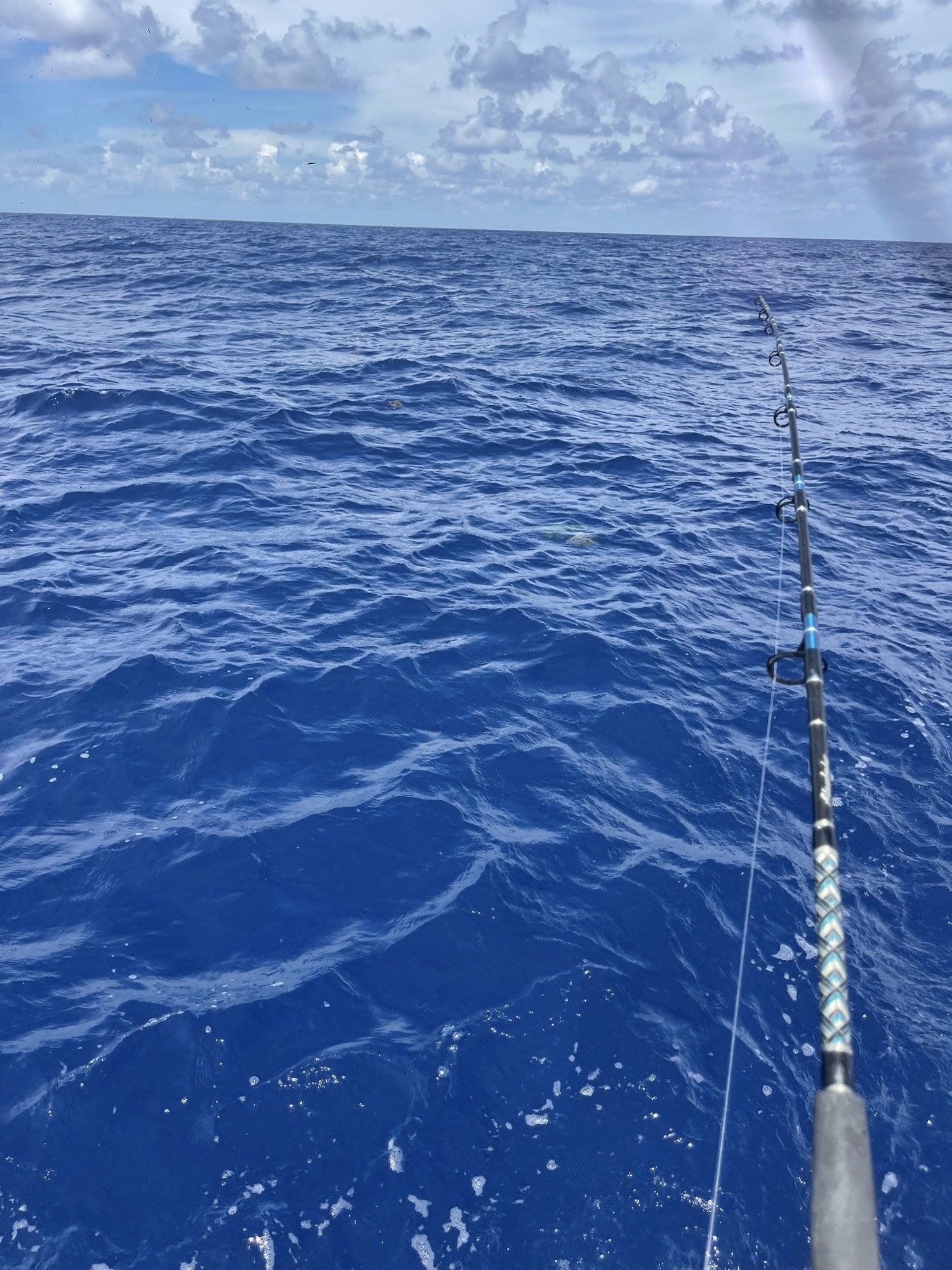 A fishing rod is sitting in the middle of a large body of water.