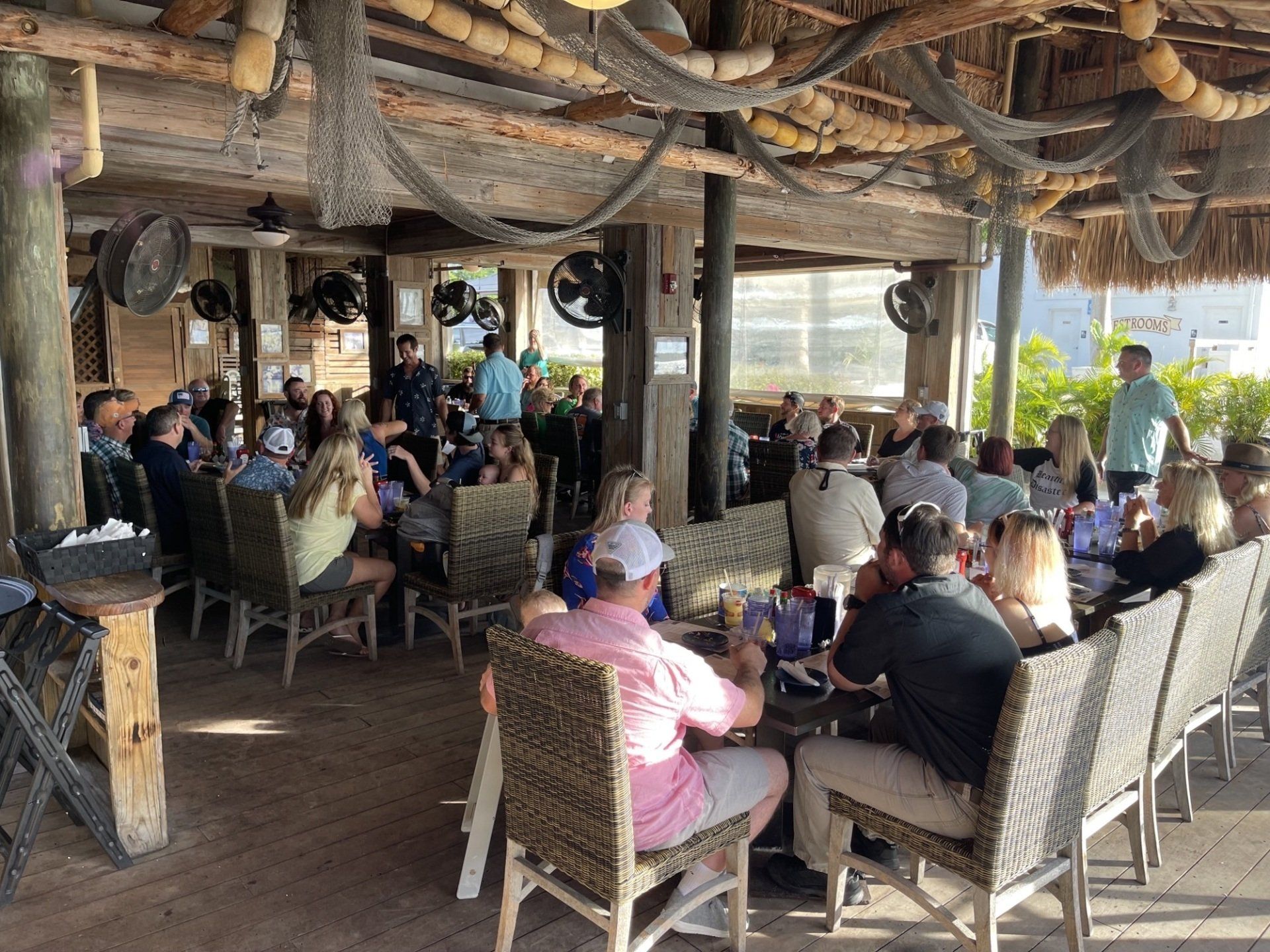 A group of people are sitting at tables in a restaurant.