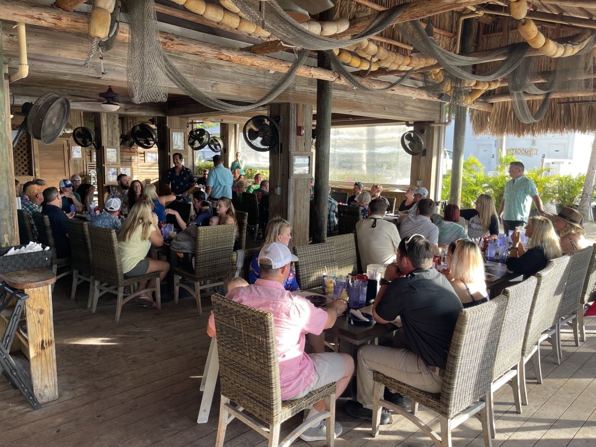 A group of people are sitting at tables in a restaurant.