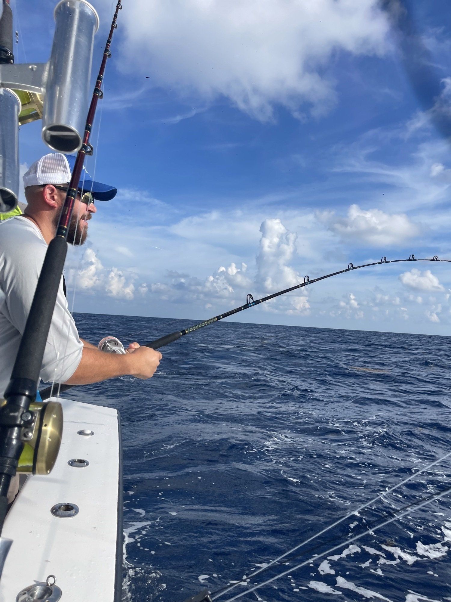 A man is fishing on a boat in the ocean.