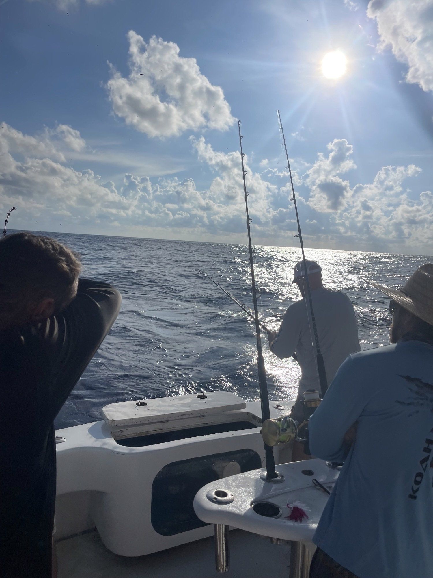 A group of men are fishing in the ocean on a boat.