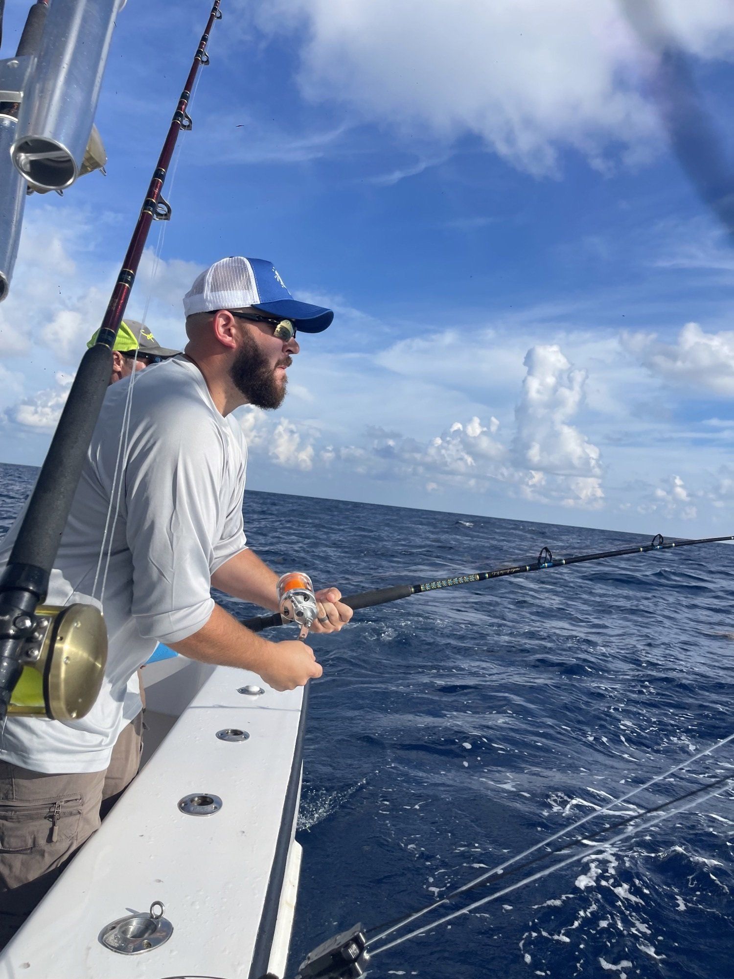 A man is fishing on a boat in the ocean.