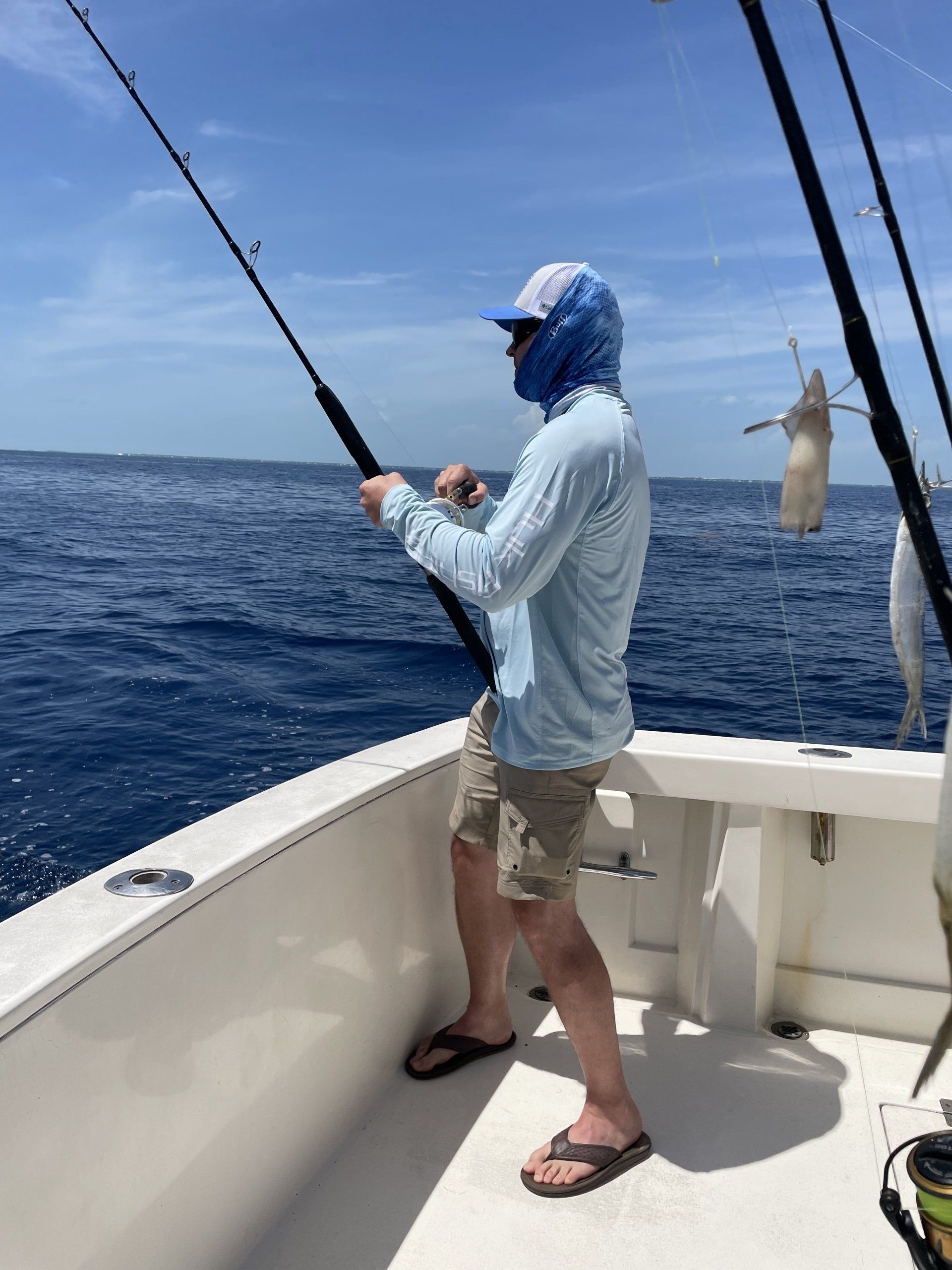 A man is fishing on a boat in the ocean.