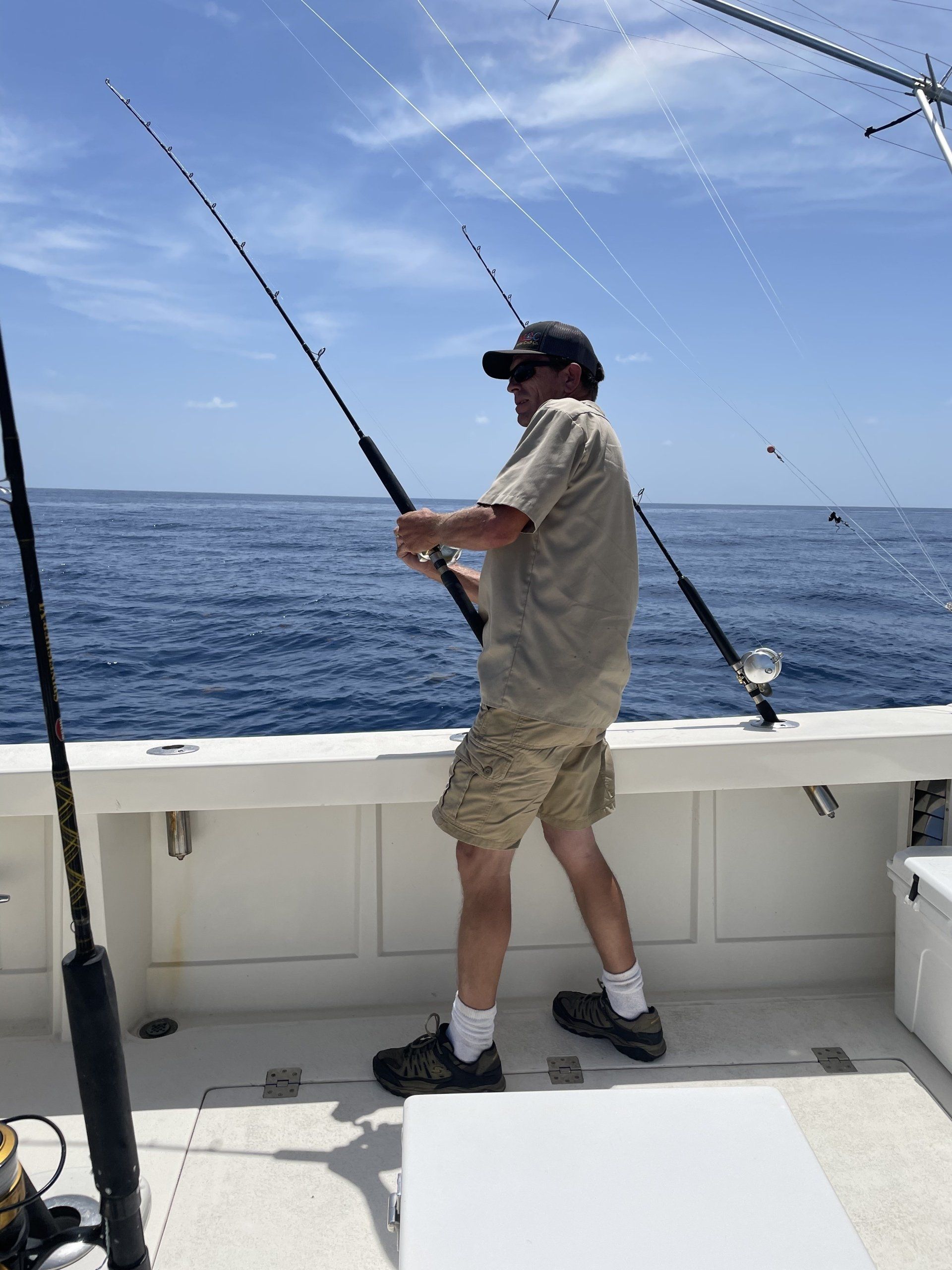 A man is fishing on a boat in the ocean