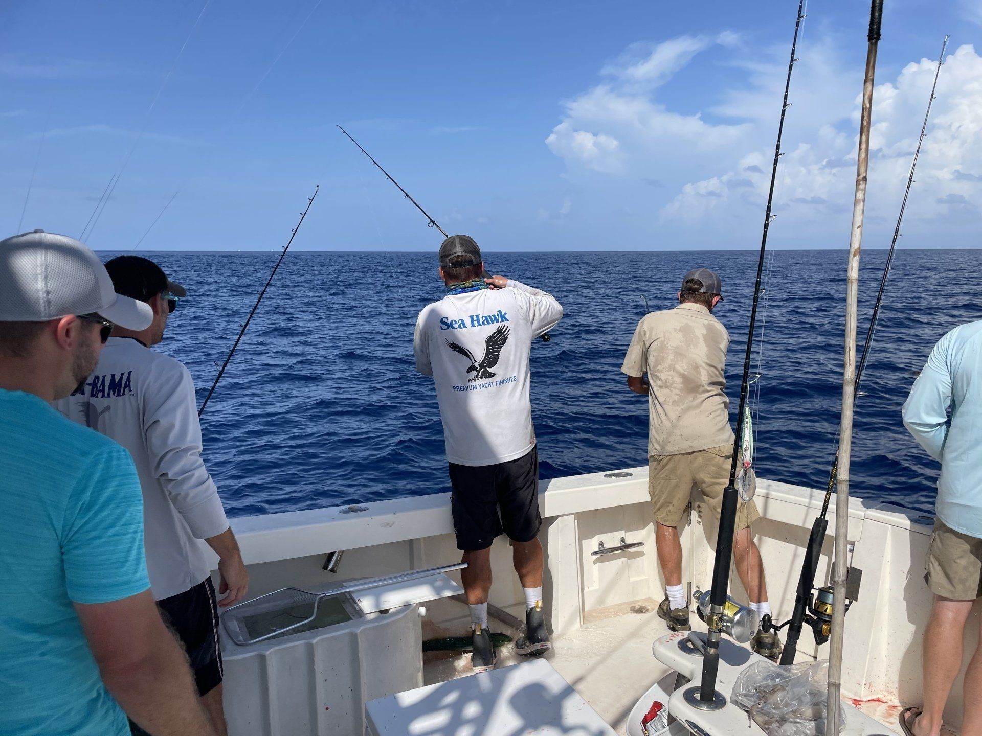 A group of men are fishing on a boat in the ocean.