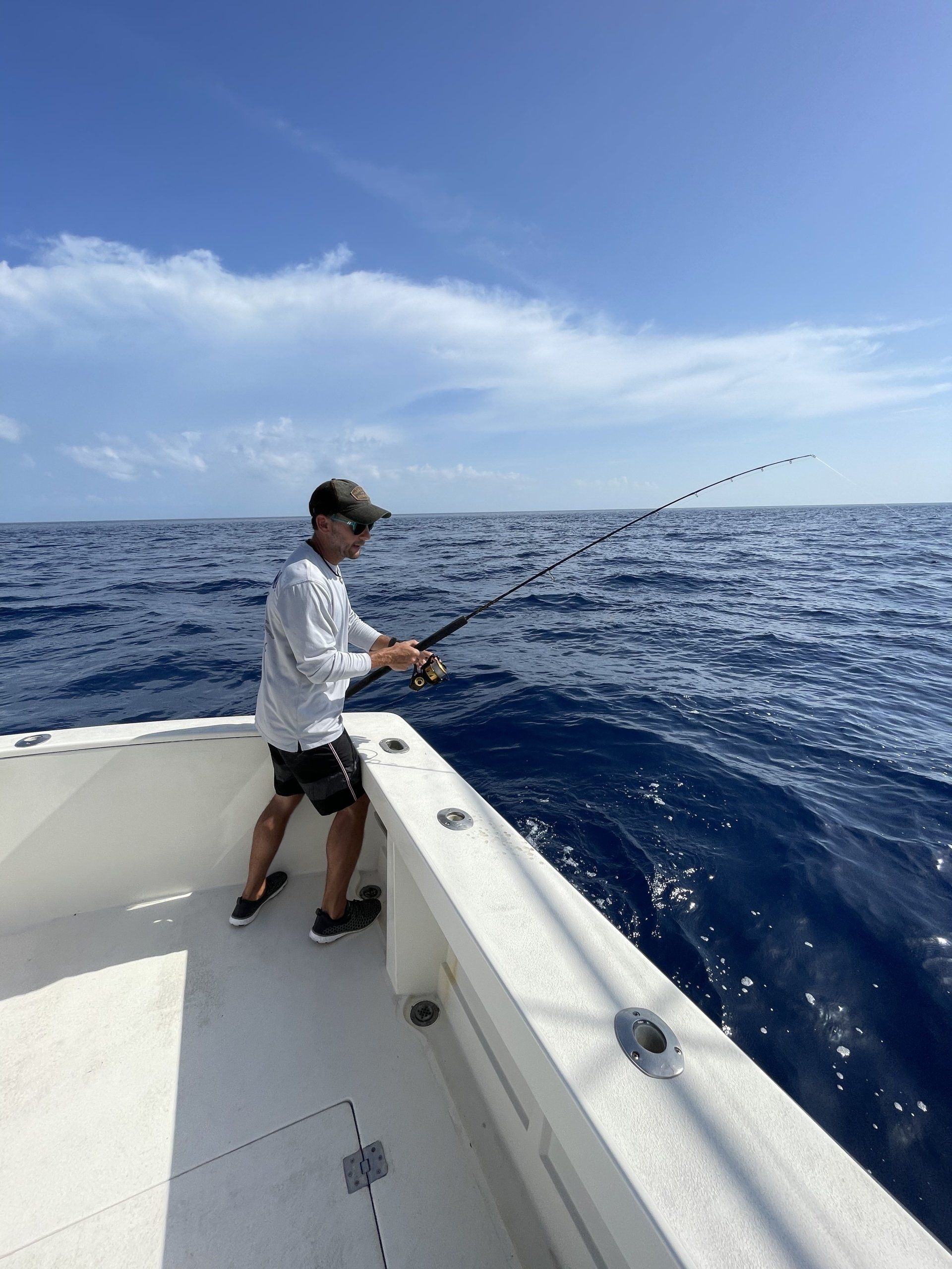 A man is fishing on a boat in the ocean